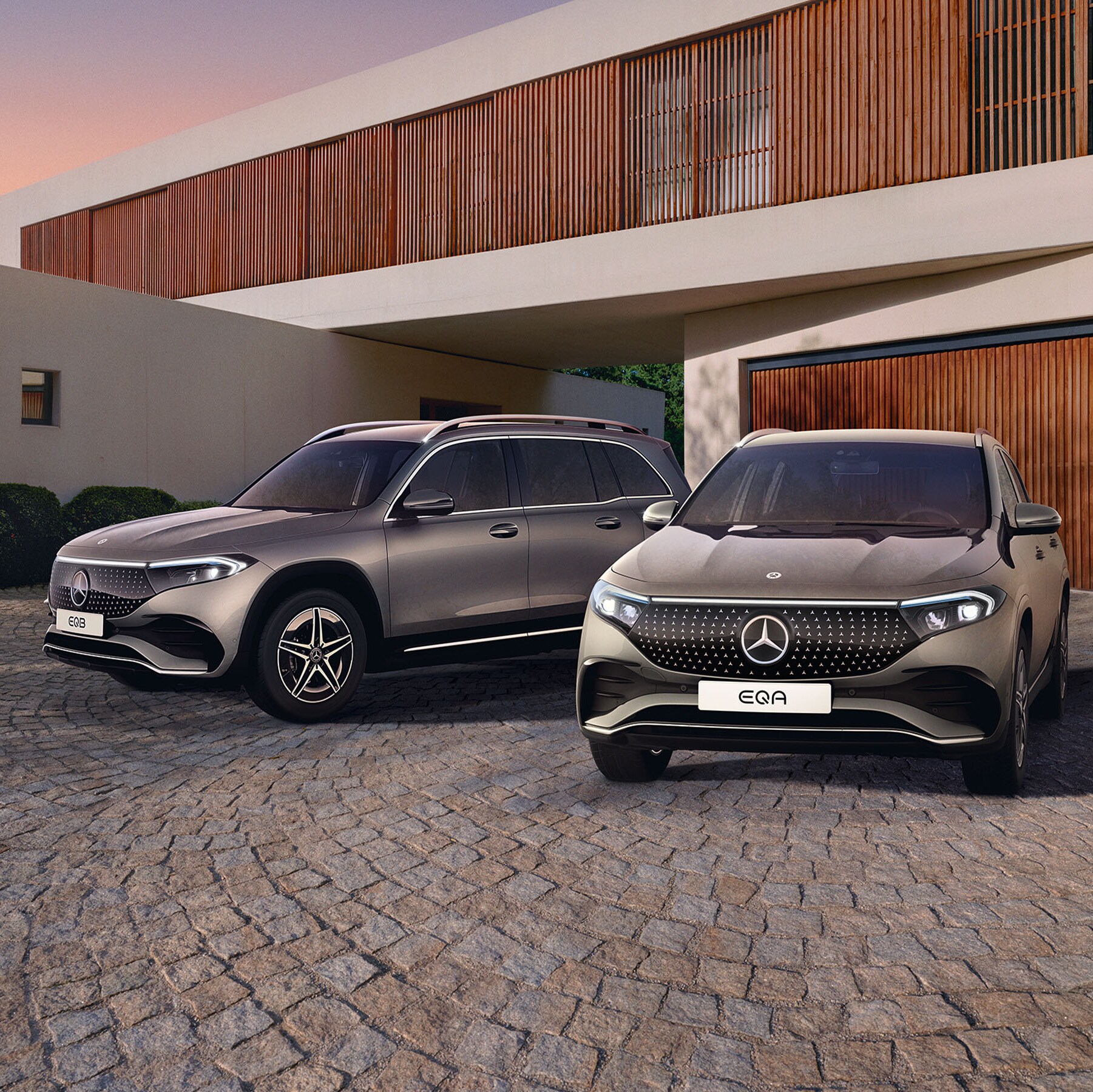 Mercedes-Benz EQA og EQB i indkørsel foran garage