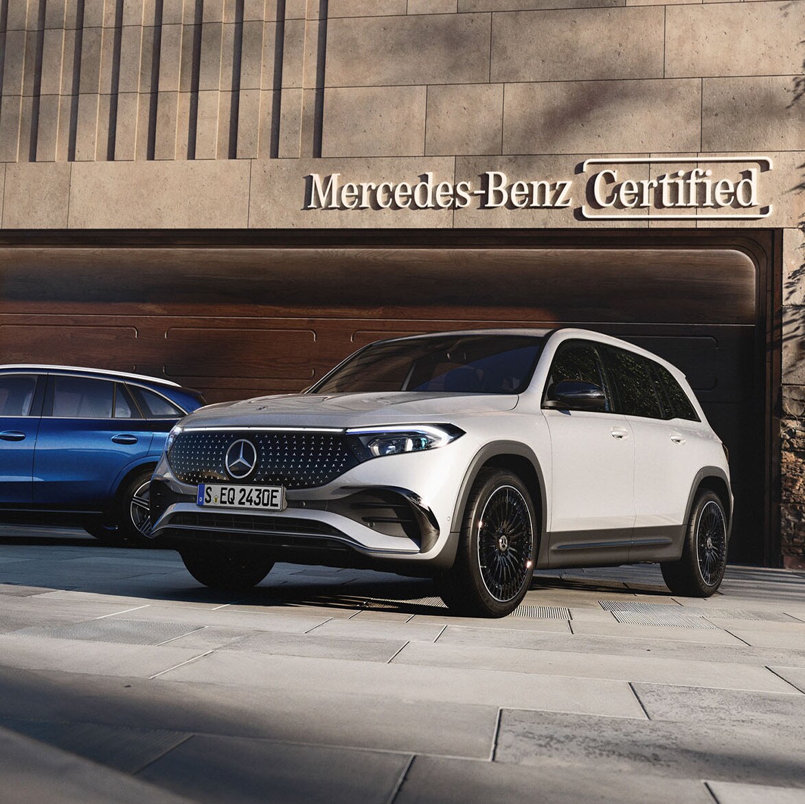 To Mercedes-Benz biler parkeret foran en Mercedes-Benz Certified garage.