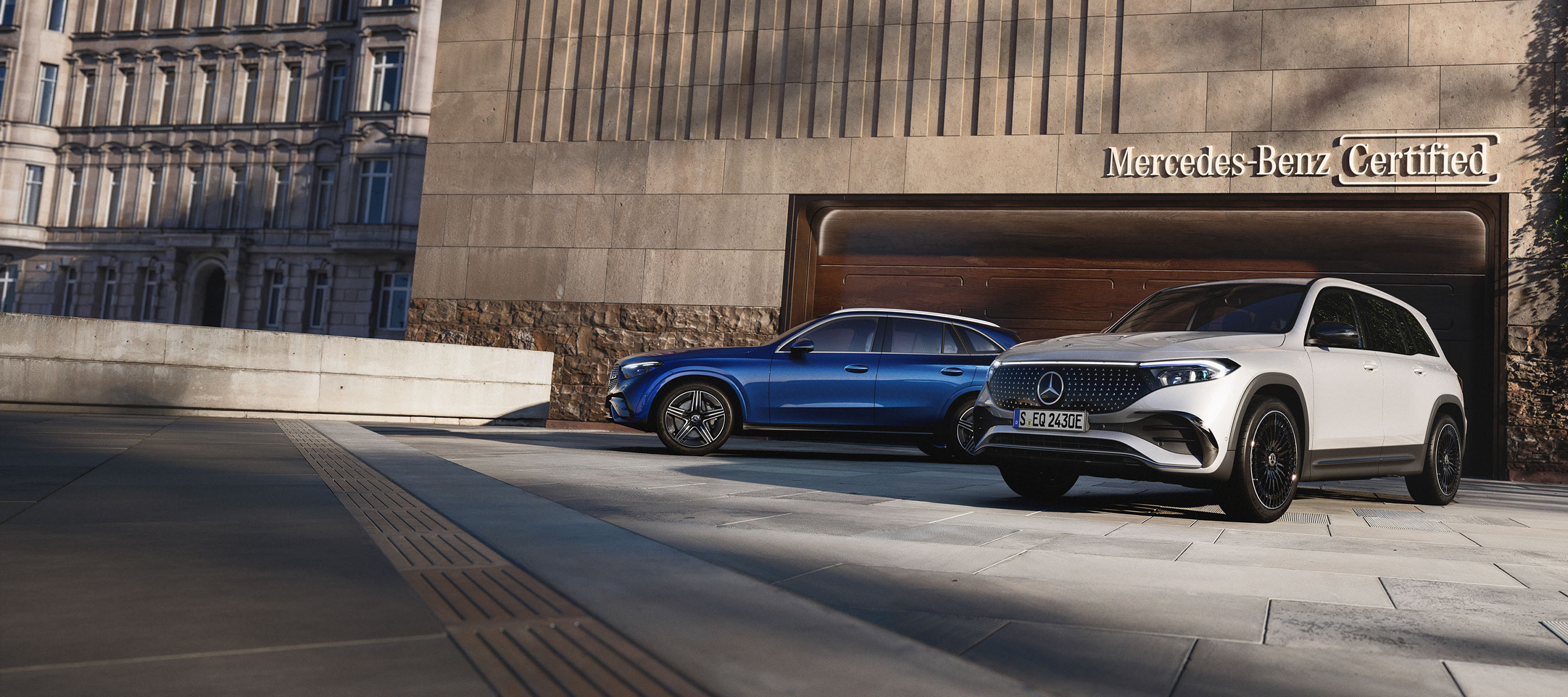 Brugtbilsstjerner | Mercedes-Benz To Mercedes-Benz biler parkeret foran en Mercedes-Benz Certified garage.