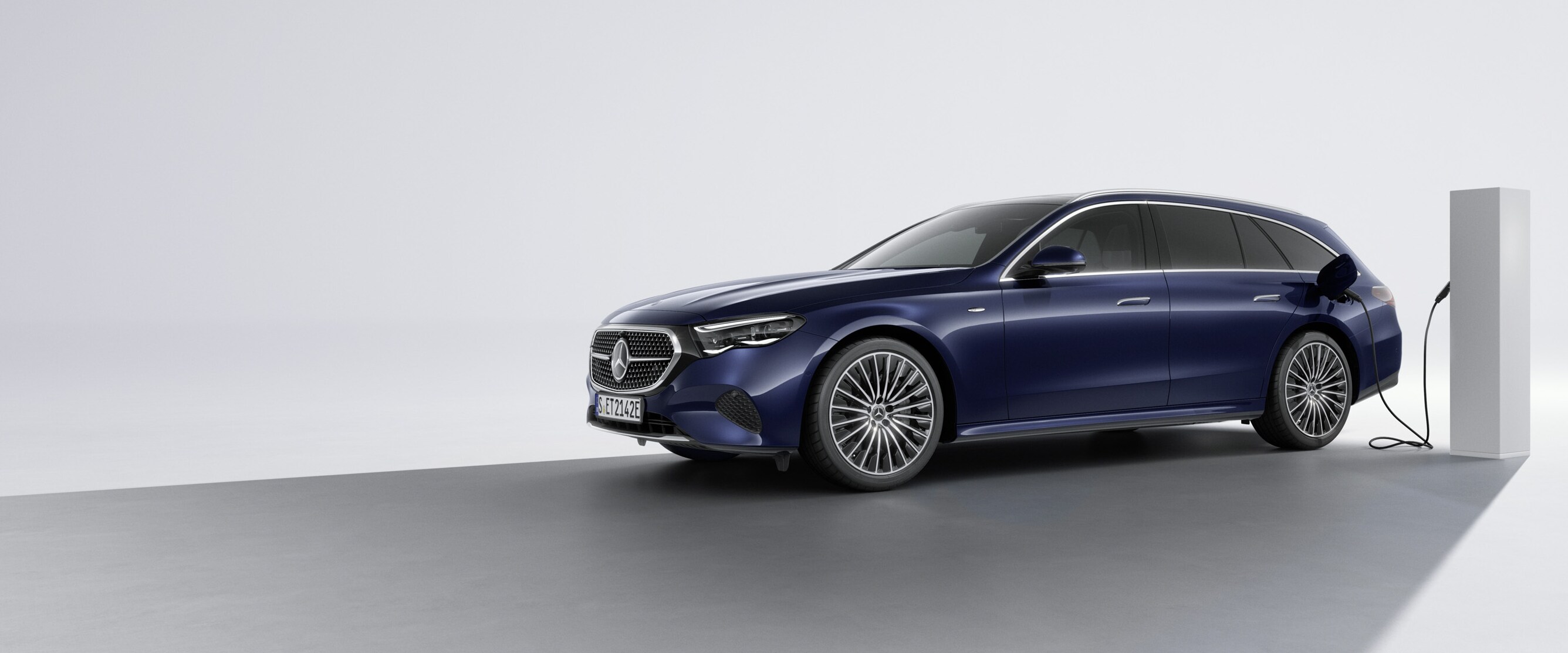 En plug-in-hybridbil fra Mercedes-Benz set skråt bagfra ved en ladestation.