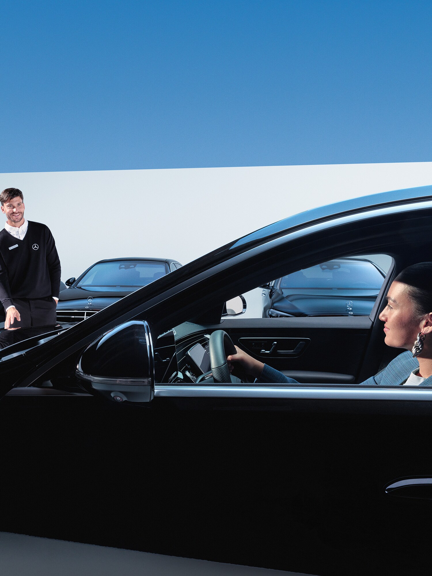 Kvinde i bil smiler til Mercedes-Benz servicemedarbejder