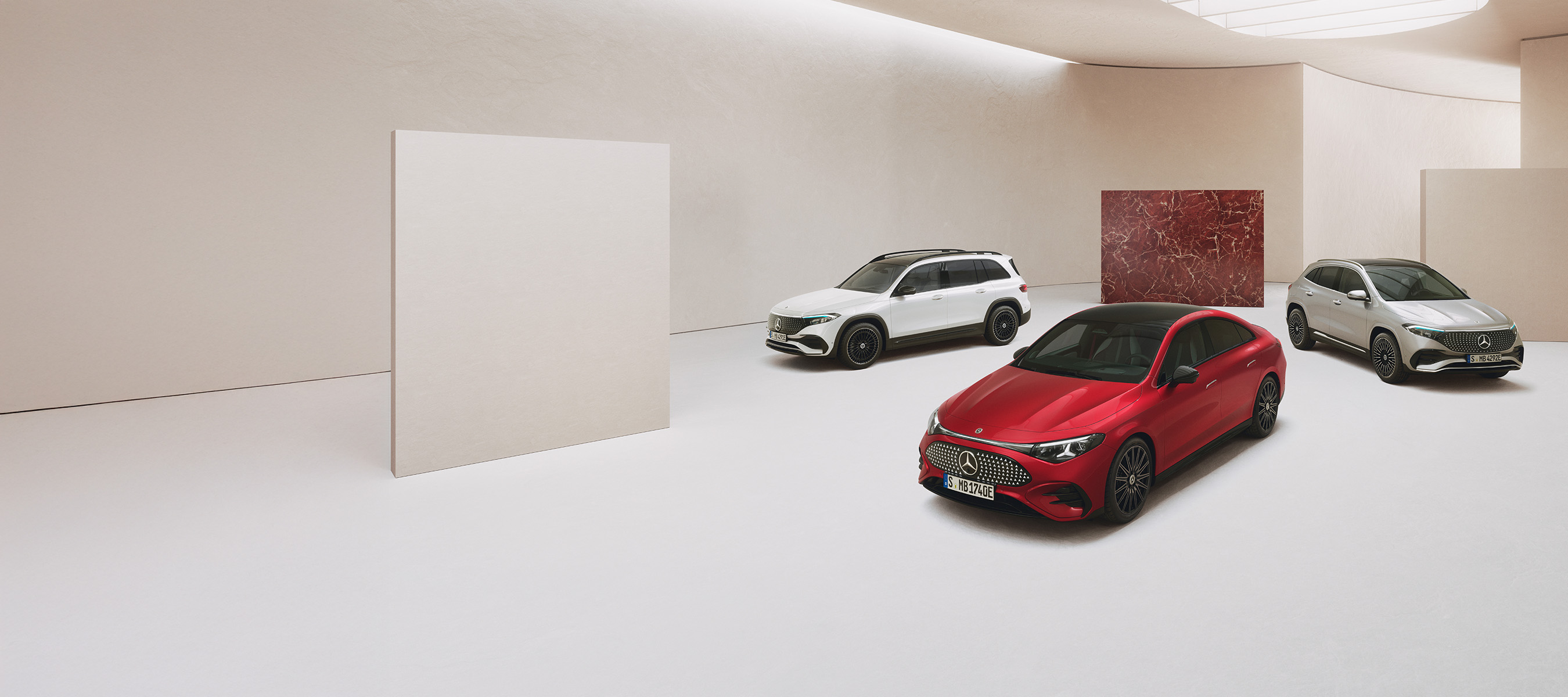 Garanti. Med lang rækkevidde | Mercedes-Benz Tre elektriske Mercedes-Benz biler holdende i et minimalistisk showroom.
