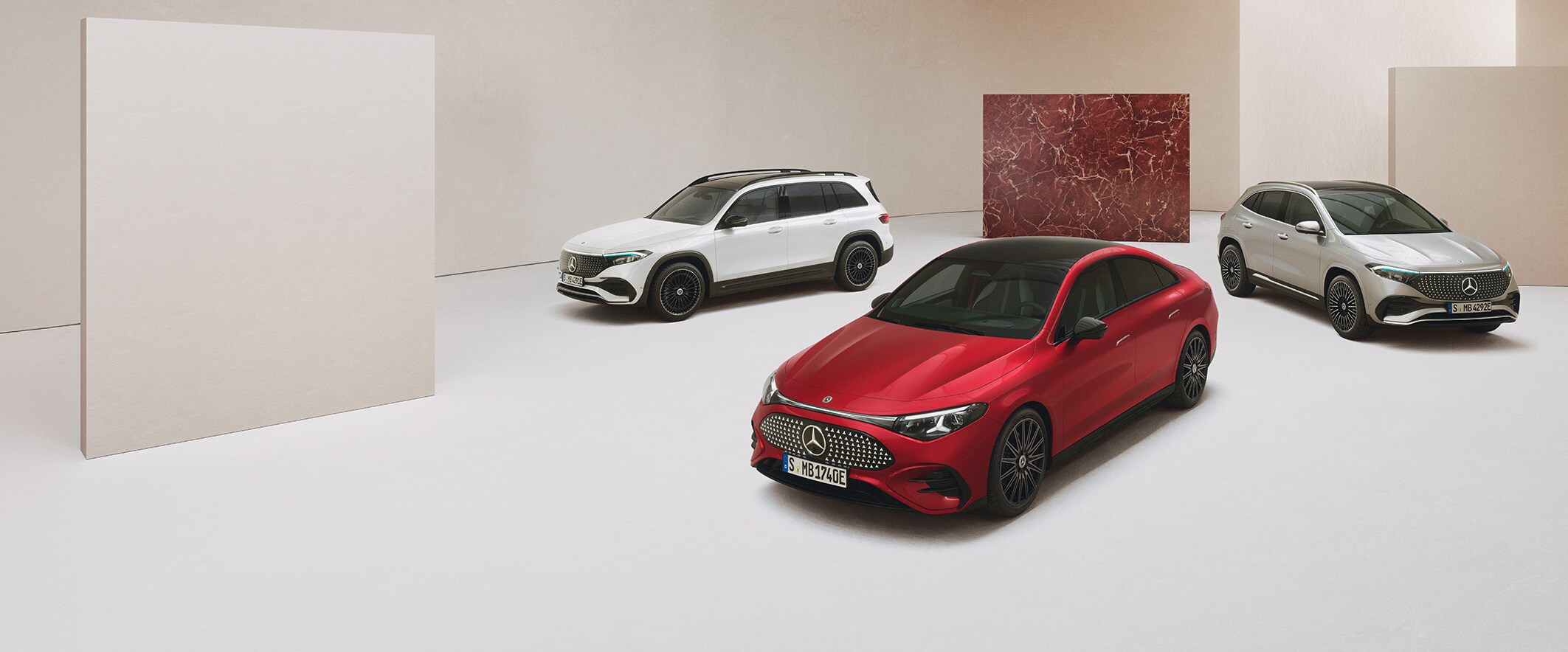 Tre elektriske Mercedes-Benz biler holdende i et minimalistisk showroom.