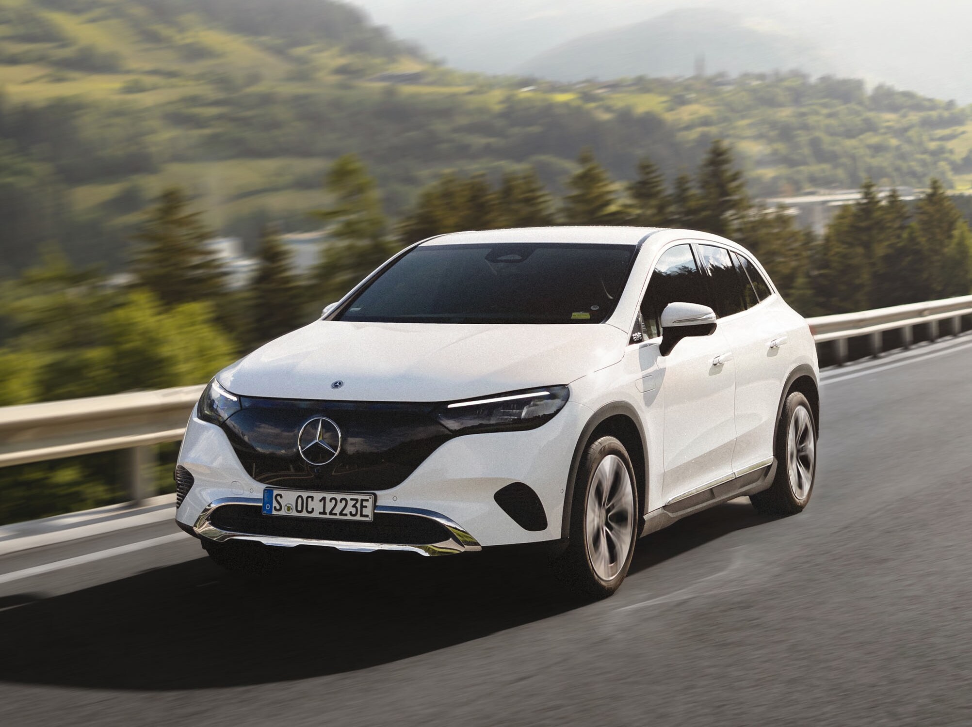 Hvid EQS SUV fra Mercedes-Benz kører på bjergrute.