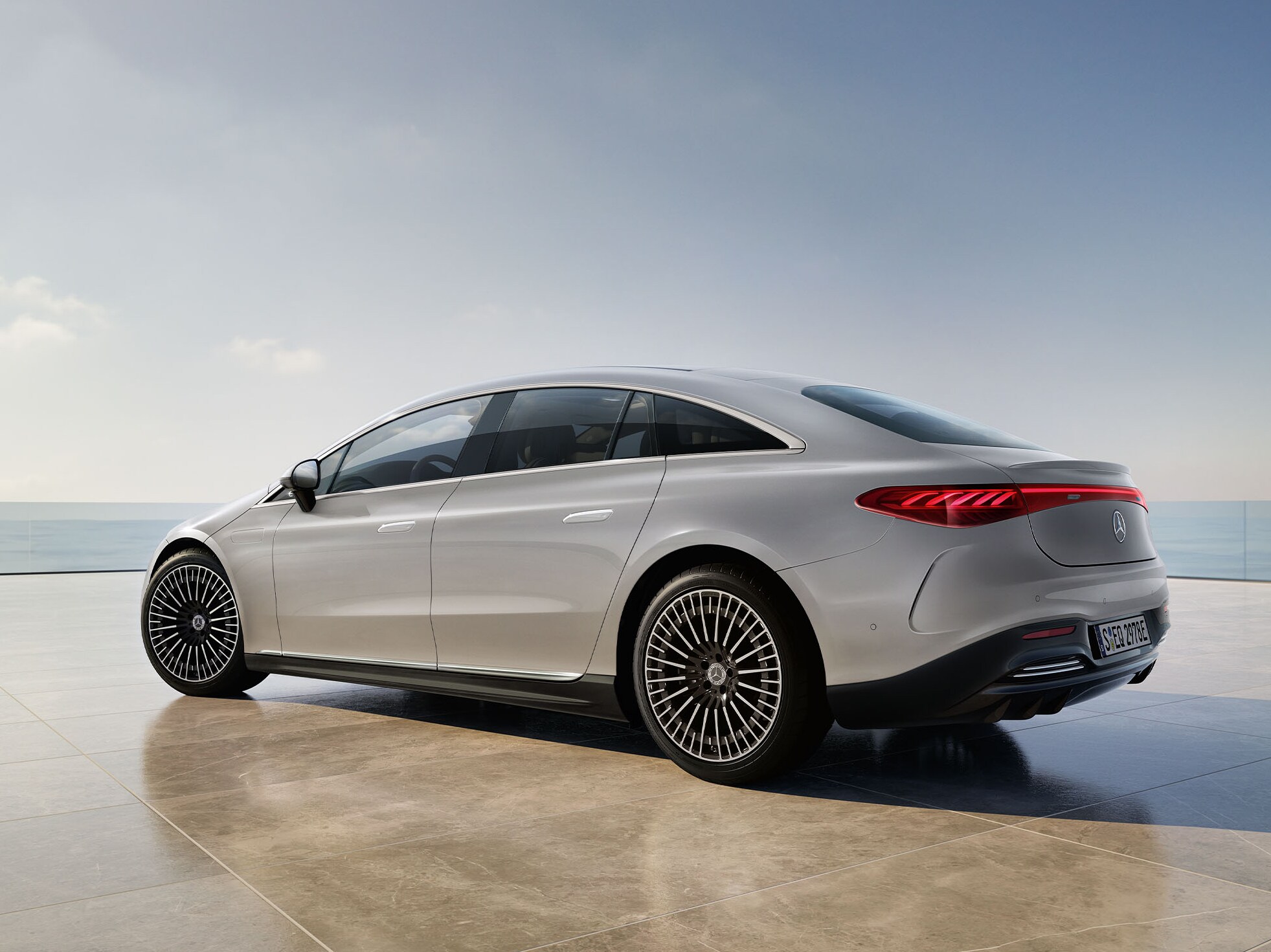 Hvid EQS Sedan fra Mercedes-Benz holder med udkig til vand.