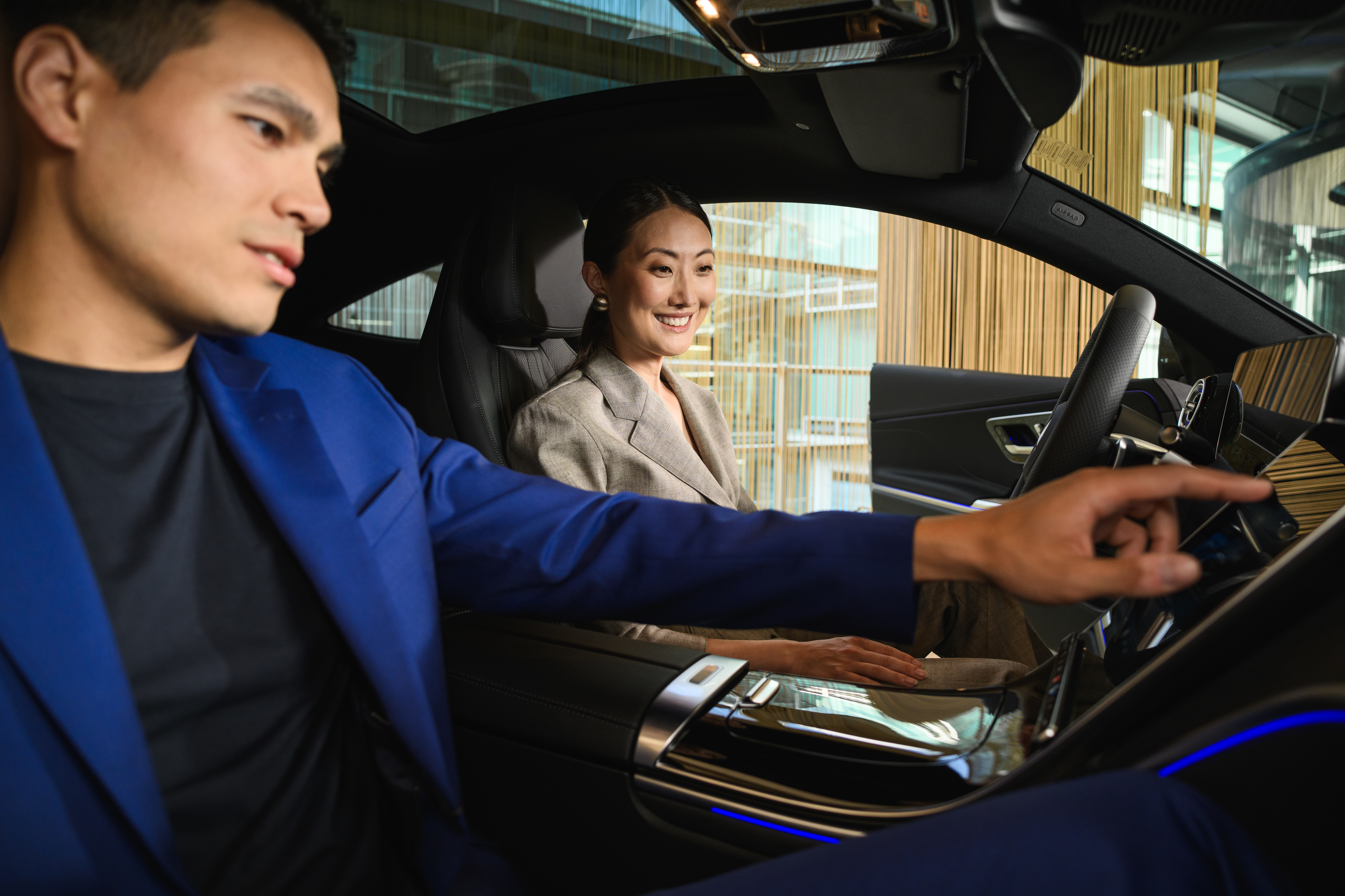 BusinessLeasing | Leasing og finansiering | Mercedes-Benz Sælger viser funktionerne i en Mercedes-Benz bil til kunde.