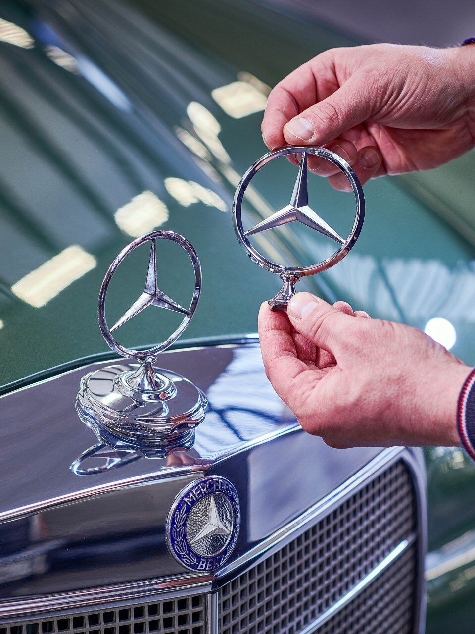 Et mand sammenligner Mercedes-stjerner på en klassisk model