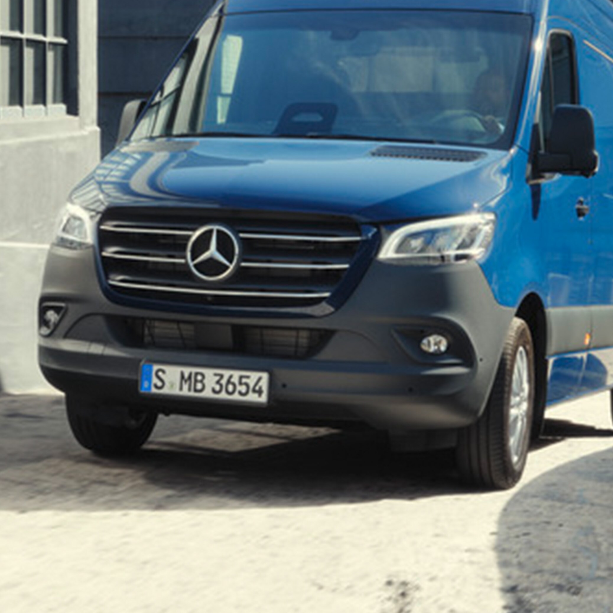 Mørkeblå Mercedes-Benz Sprinter Kassevogn navigerer på byggeplads