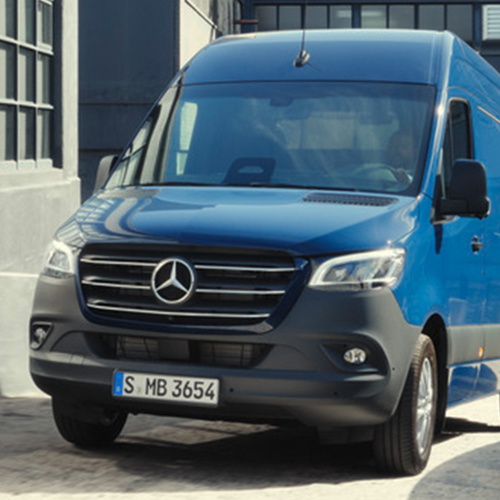 Mørkeblå Mercedes-Benz Sprinter Kassevogn navigerer på byggeplads