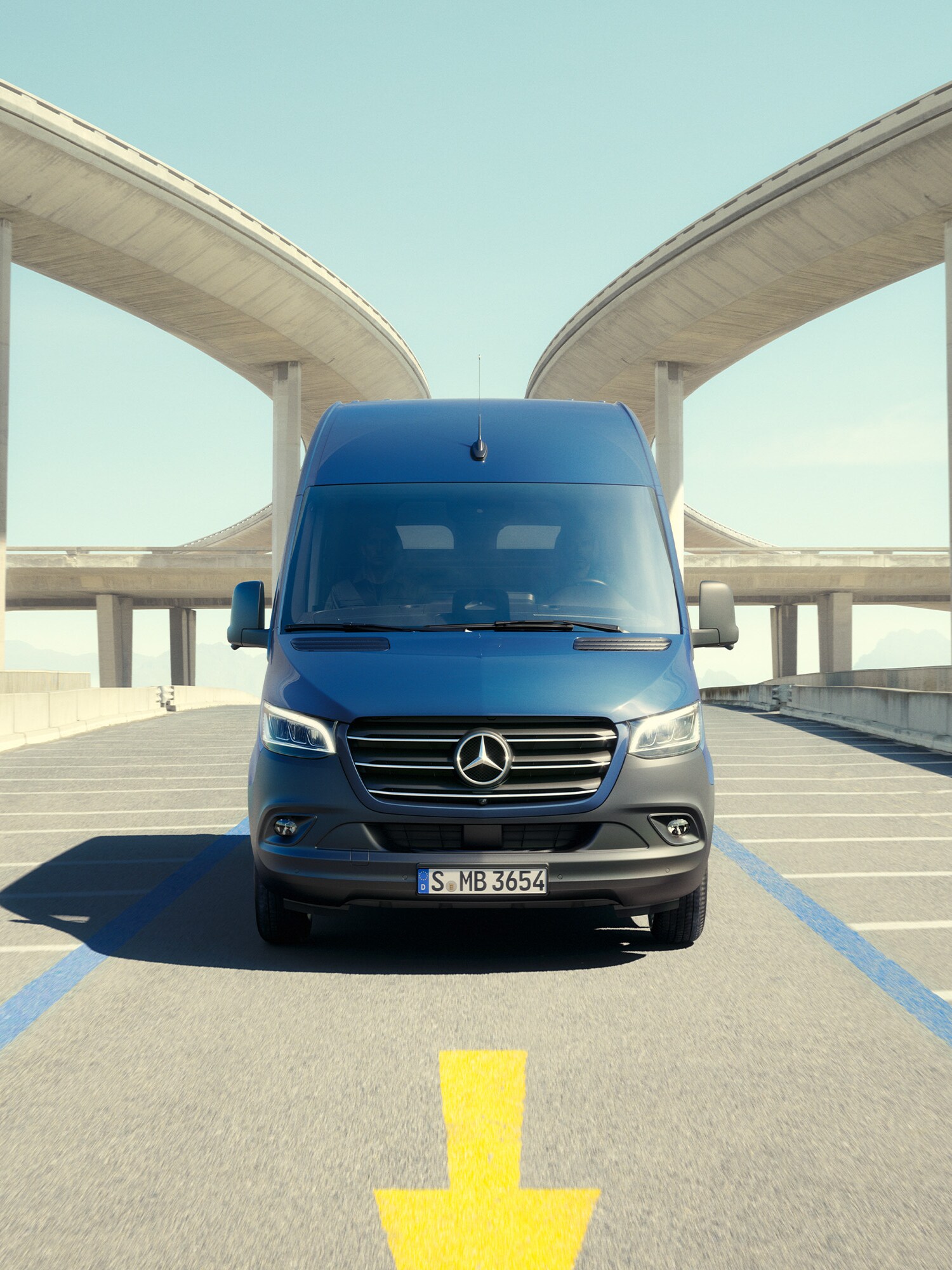 Mørkeblå Sprinter holder parkeret med betonkonstruktioner til begge sider