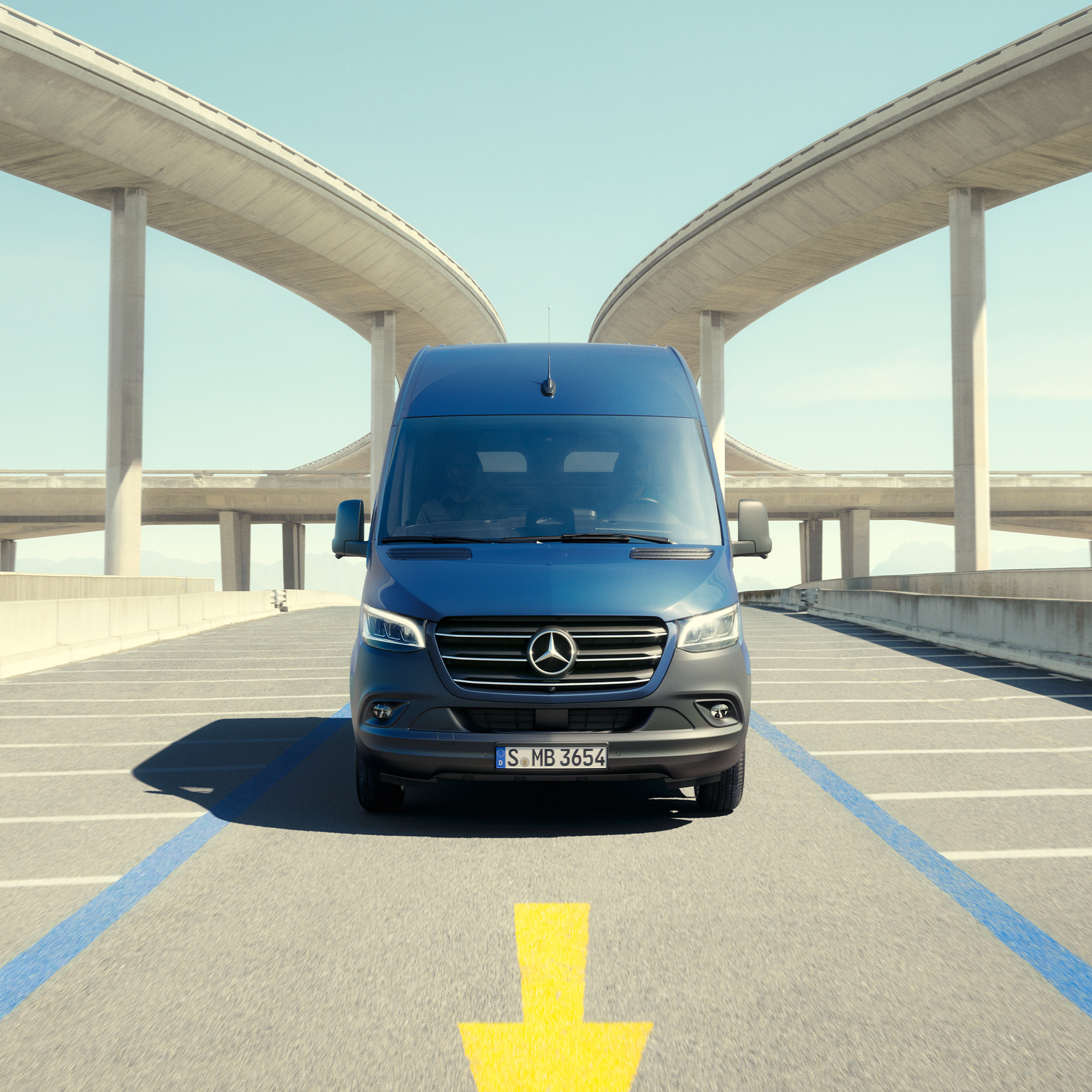 Ny Sprinter og eSprinter hæver standarden | Mercedes-Benz Vans Mørkeblå Sprinter holder parkeret med betonkonstruktioner til begge sider