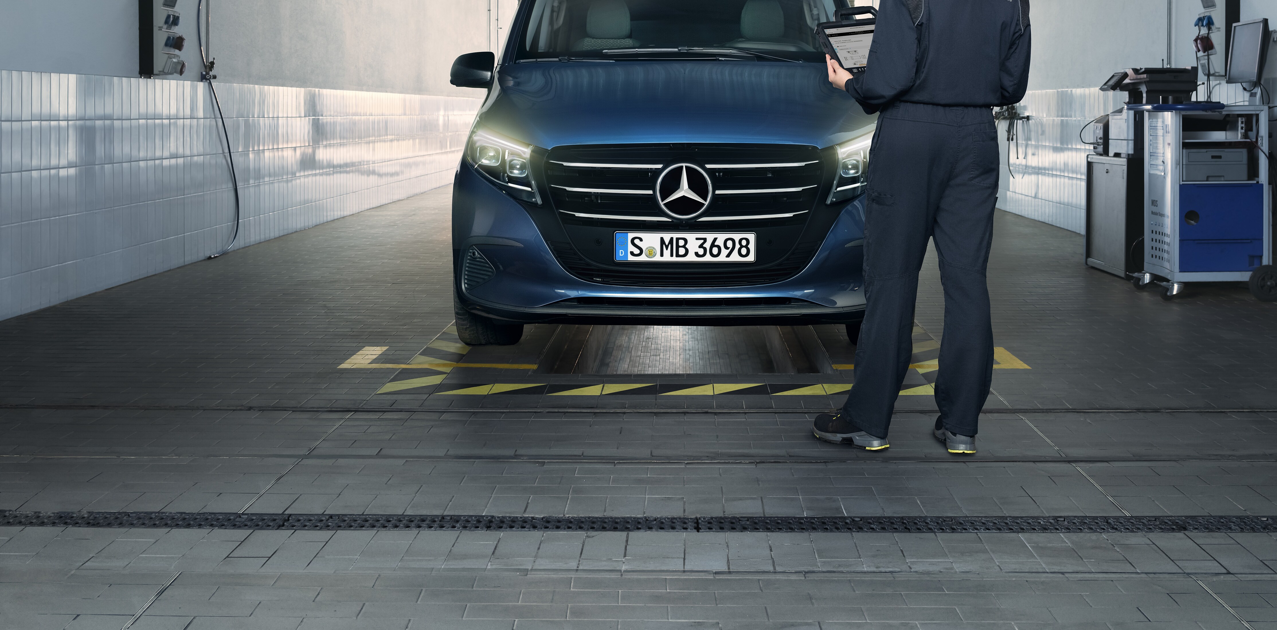Mercedes-Benz servicemedarbejder foretager servicetjek på værksted foran en Vito 