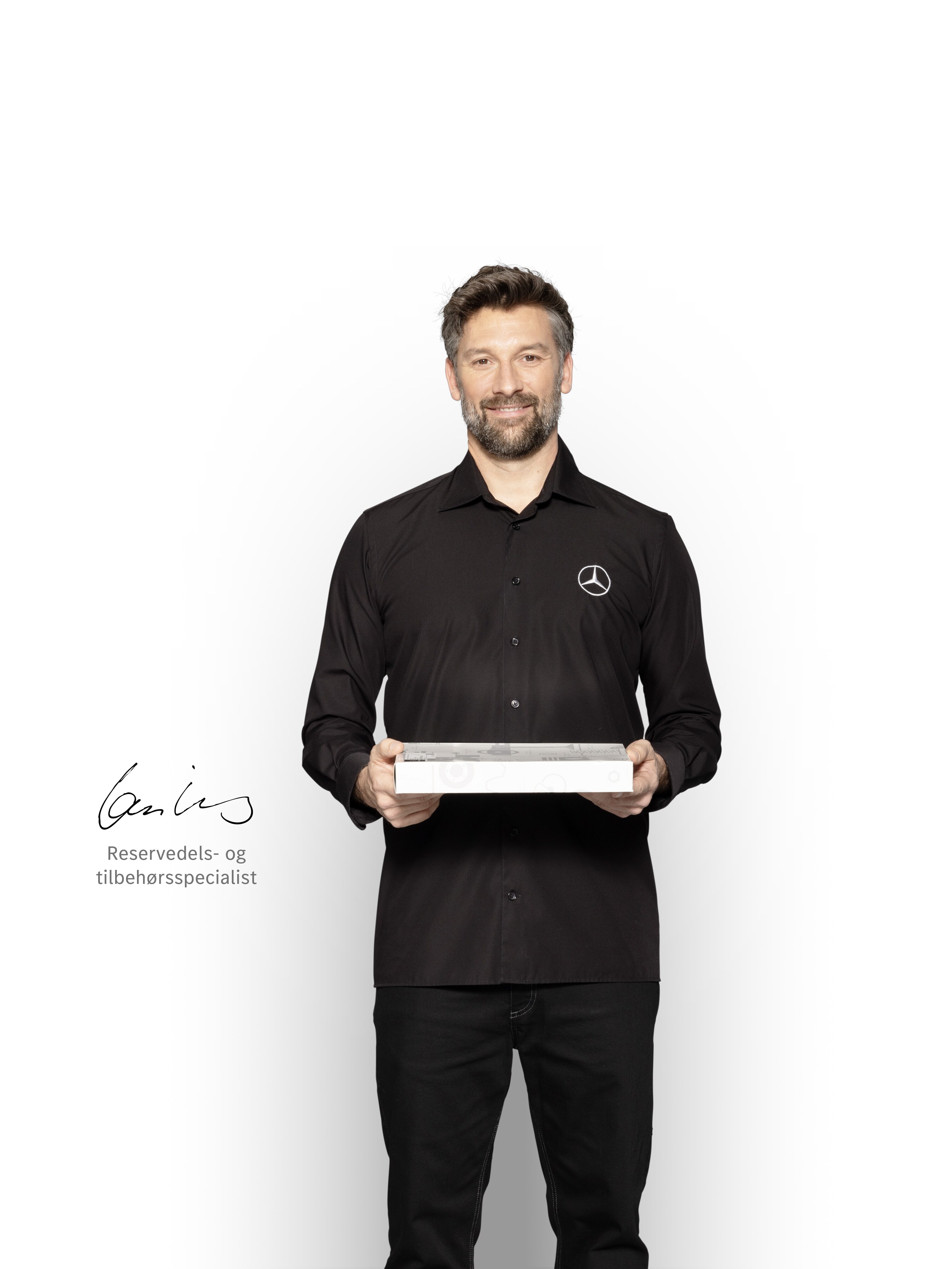 Reservedelsspecialist med tablet klar til at informere om Mercedes-Benz' kvalitetsstandarder