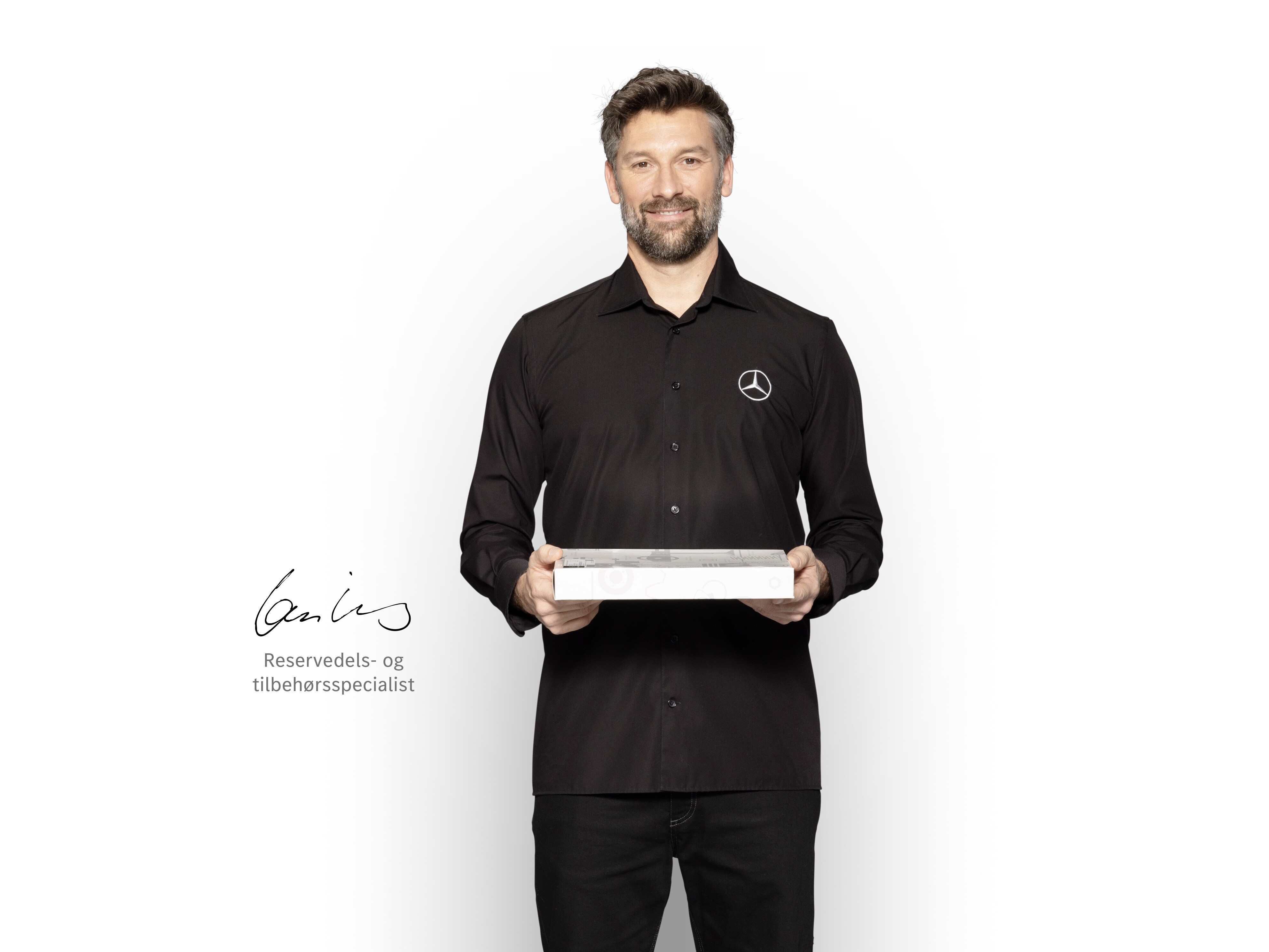 Reservedelsspecialist med tablet klar til at informere om Mercedes-Benz' kvalitetsstandarder