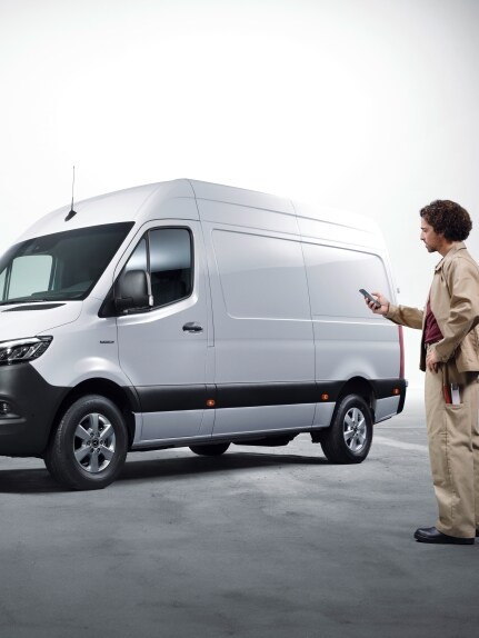 Mand bruger Mercedes-Benz digitale tjenester. I baggrunden holder en varevogn