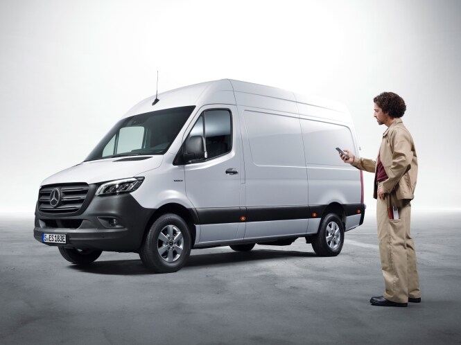 Mand bruger Mercedes-Benz digitale tjenester. I baggrunden holder en varevogn
