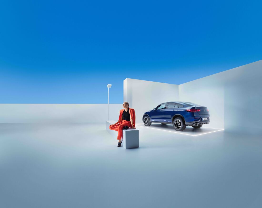 Mercedes-Benz serviceaftaler | Mercedes-Benz Online Person sidder på bænk ved siden af sin parkerede blå Mercedes-Benz