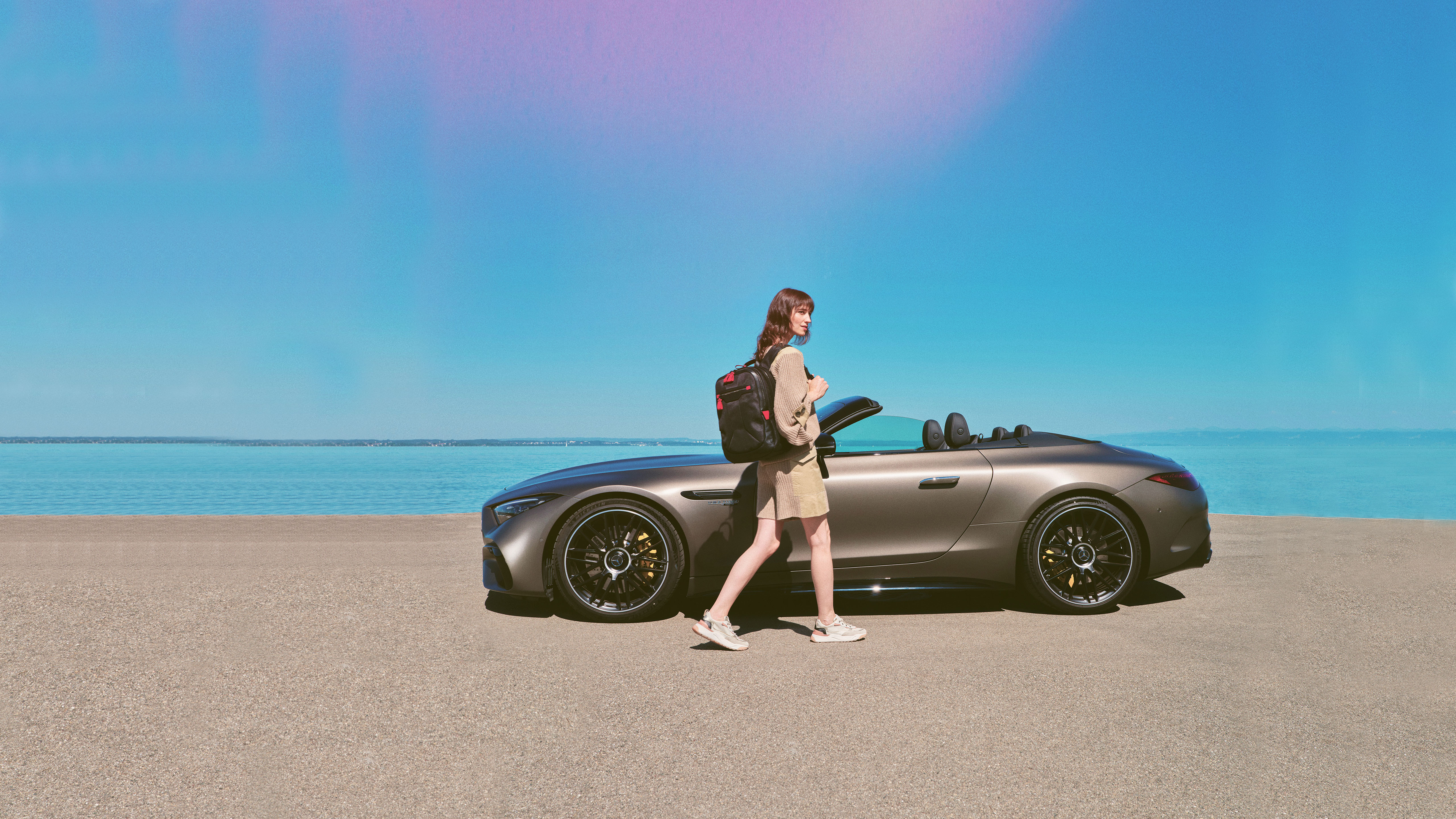 Mercedes-Benz-kollektion Kvinde går mod Mercedes-Benz cabriolet parkeret ved strand