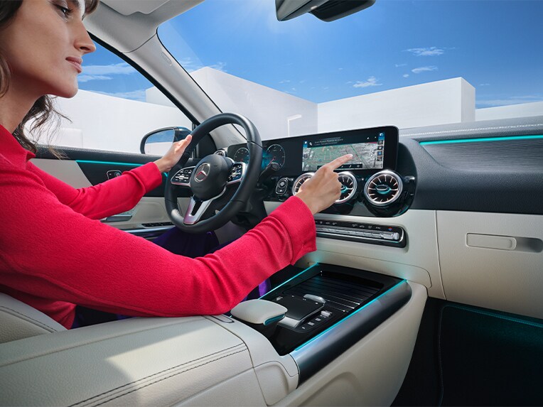 Kvinde bruger multimediesystemet i Mercedes-Benz til at søge efter destination
