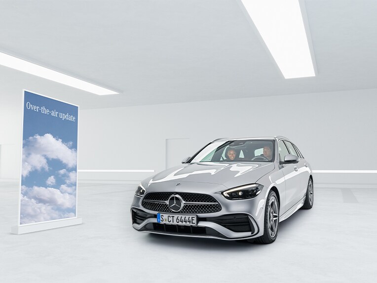To personer sidder i en parkeret Mercedes-Benz