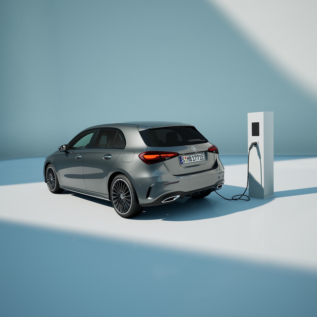 Billede af en Mercedes-Benz A 250 e med EQ-hybridteknologi, der holder ved en ladestation.