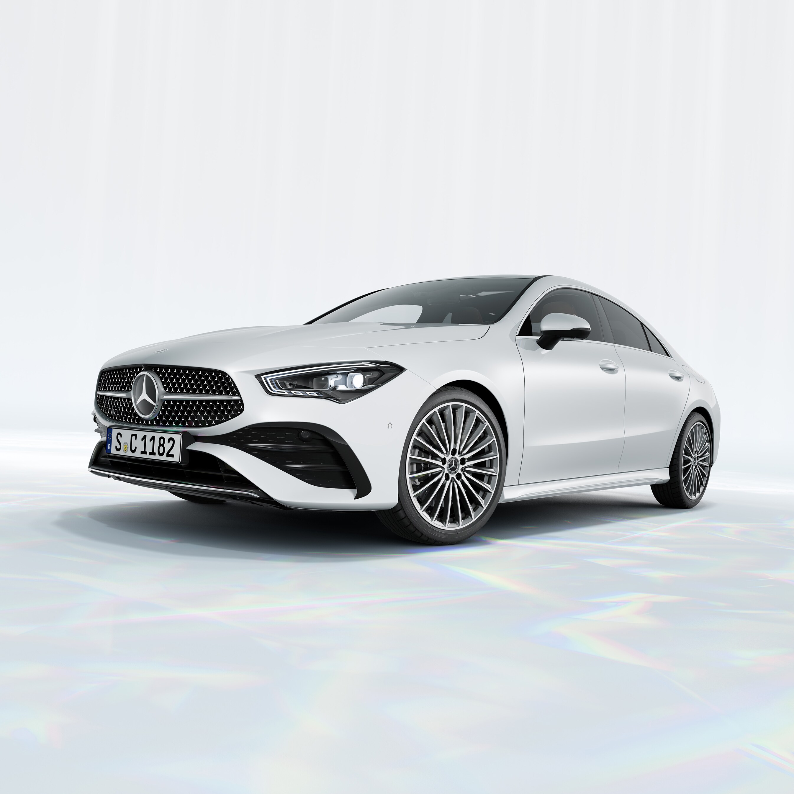 Hvid Mercedes-Benz CLA Coupé set skråt forfra på minimalistisk baggrund