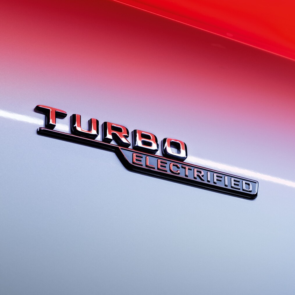 Nærbillede af TURBO ELECTRIFIED-emblemet på frontskærmene