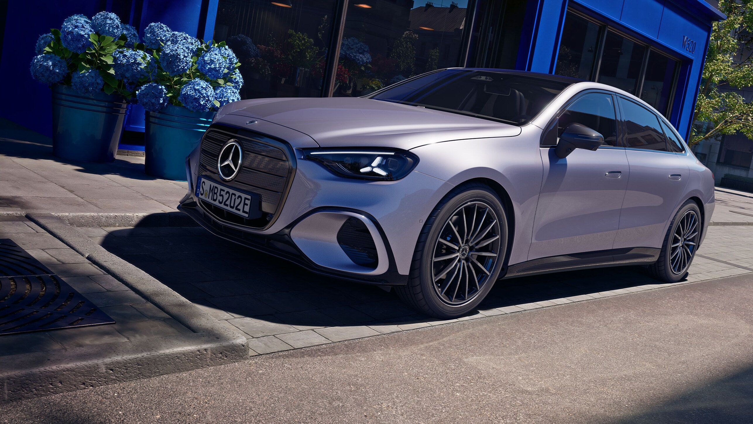 Den nye elektriske Mercedes-Benz C-Klasse parkeret foran lavendelblå butiksfacade