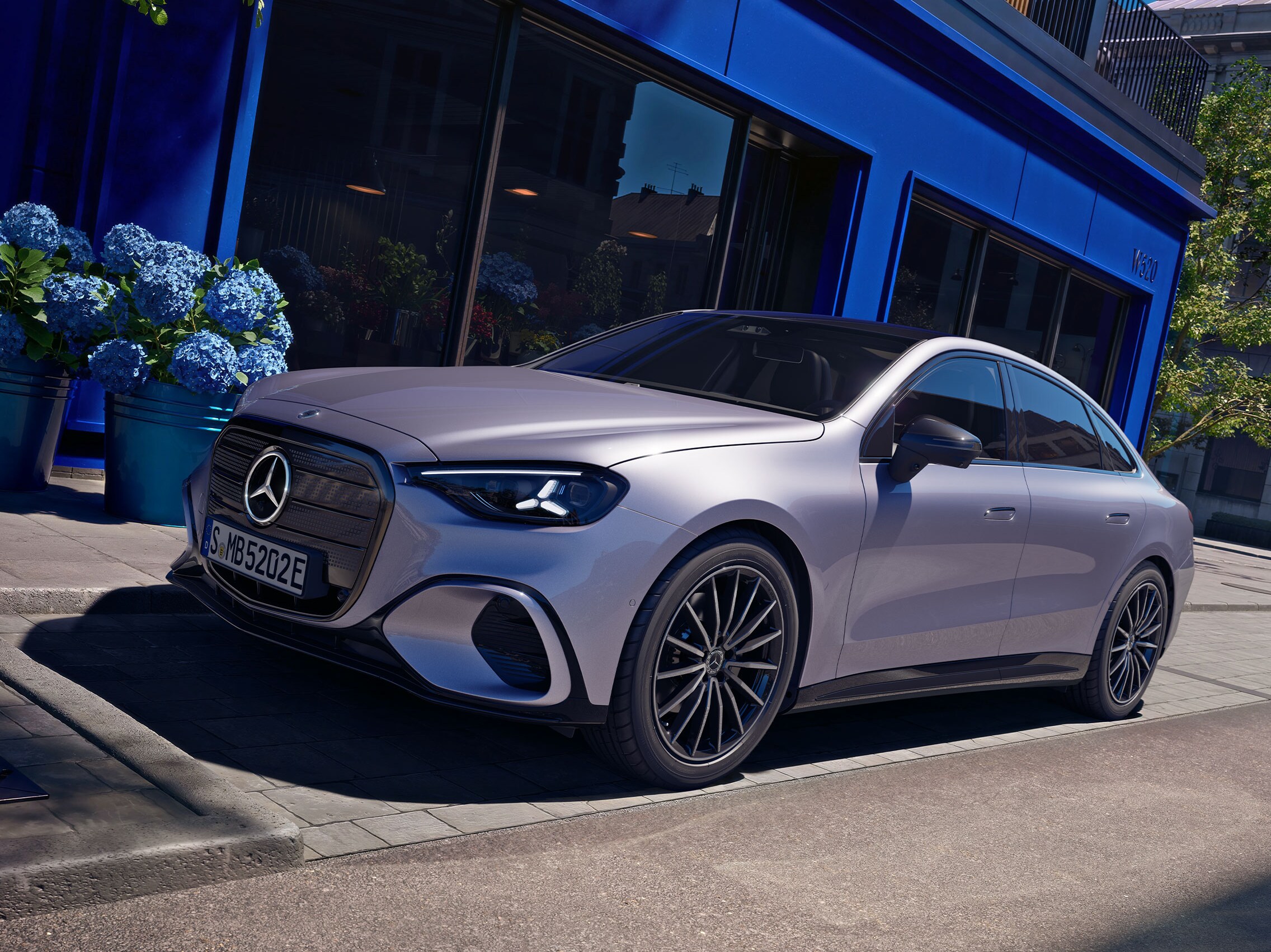 Den elektriske C-Klasse fra Mercedes-Benz parkeret foran en butik.