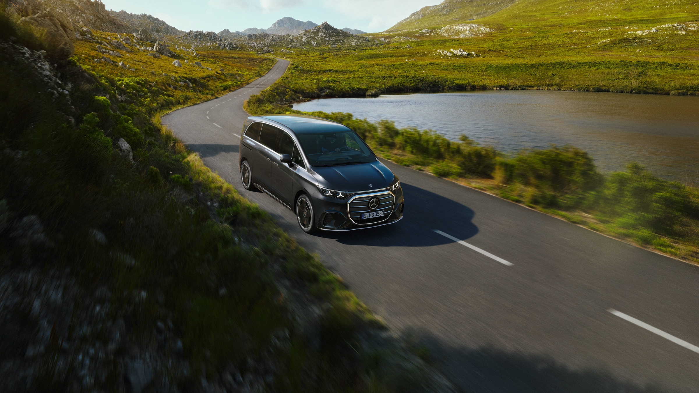 Store familiebiler | Grand Limousine VLE | Mercedes-Benz MPV Mercedes‑Benz VLE på smuk landevej langs sø med fokus på luksuriøs komfort