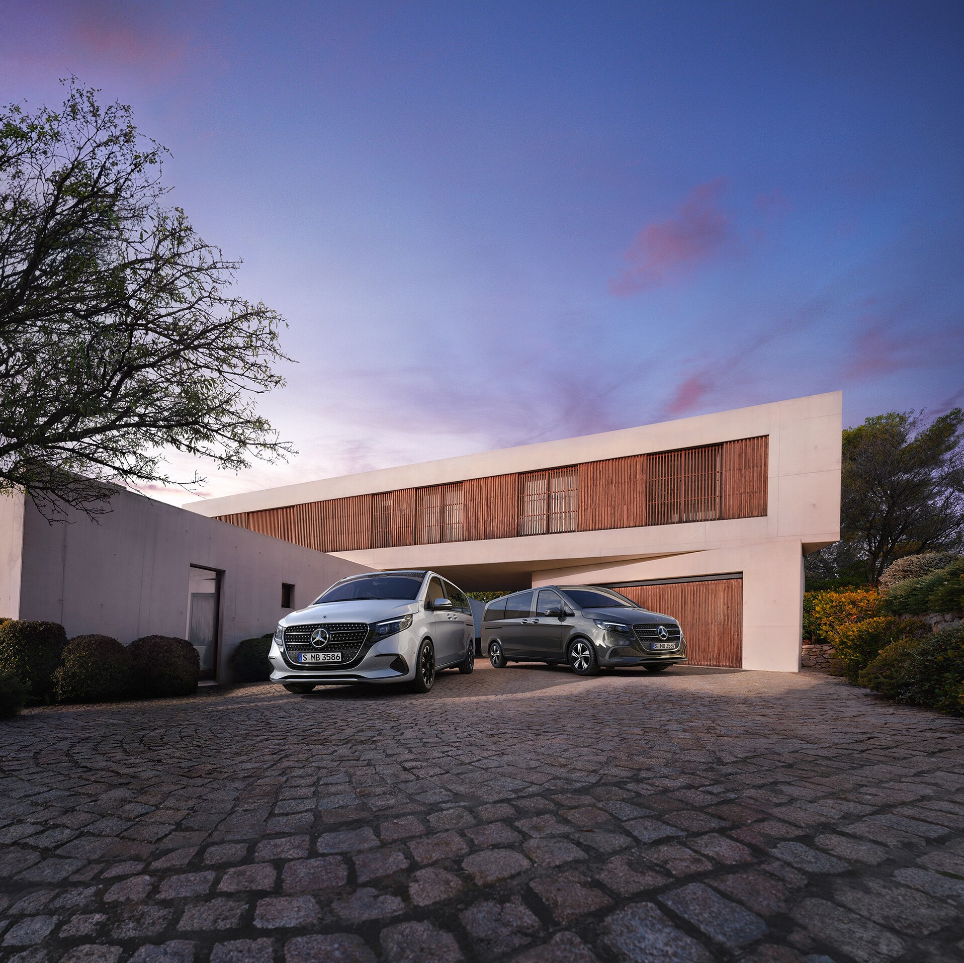 Mercedes‑Benz V‑Klasse foran et moderne luksushus i tusmørke.