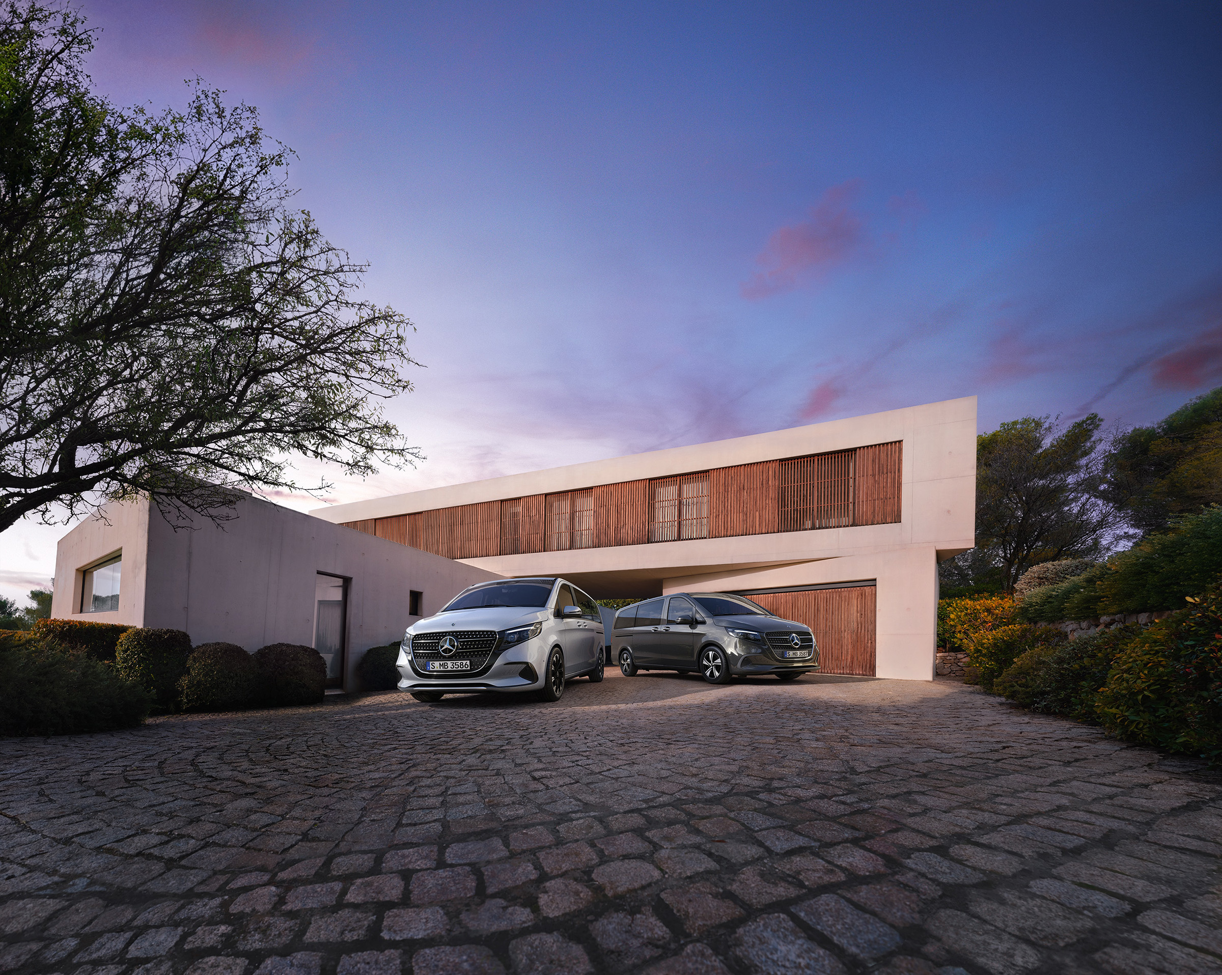 Store familiebiler | Mercedes-Benz MPV Mercedes‑Benz V‑Klasse foran et moderne luksushus i tusmørke.