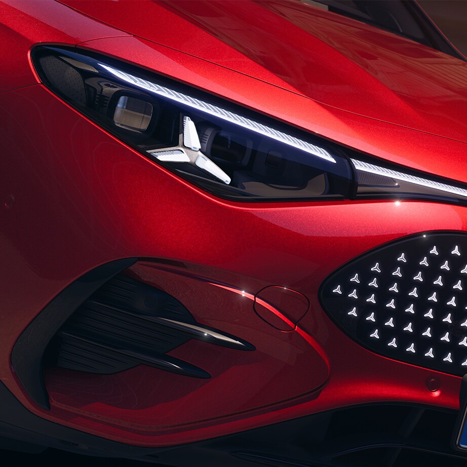 Grå Mercedes-Benz EQB parkeret foran garage ved arkitekttegnet hus