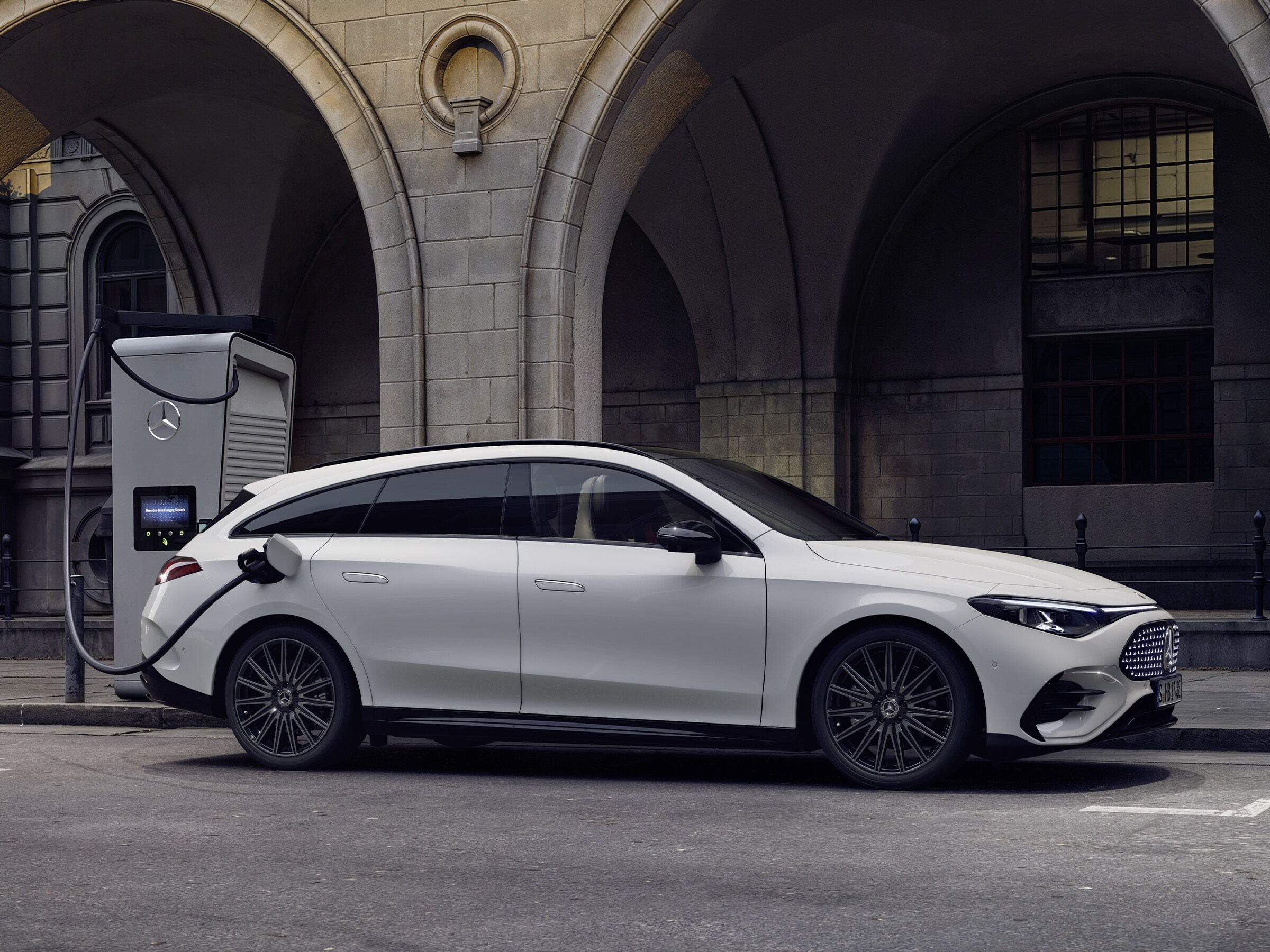 Hvid CLA fra Mercedes-Benz oplader ved offentligt ladestander.