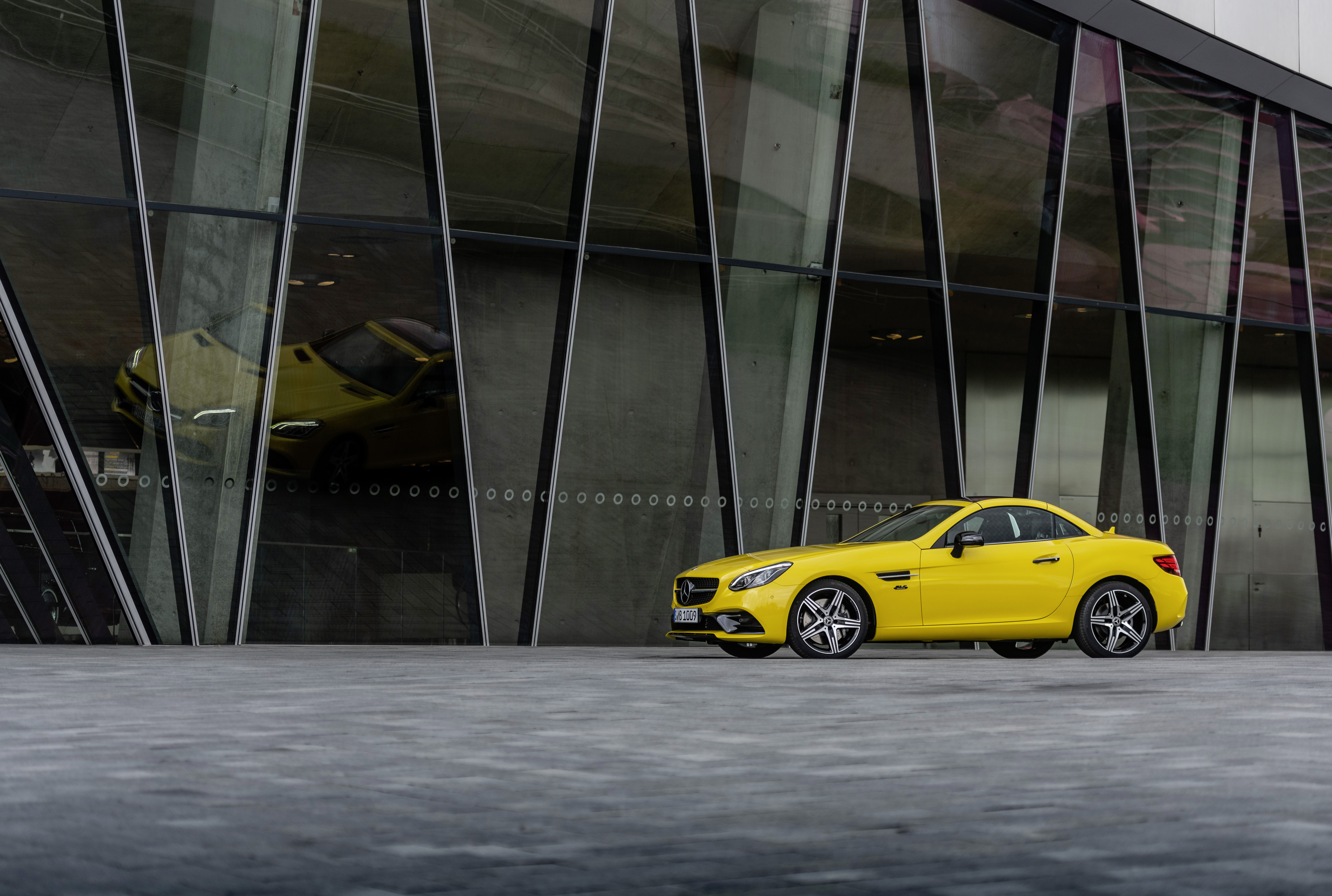 Tidligere modeller | Mercedes-Benz Gul Mercedes-Benz SLC final edition parkeret foran en stor bygning.