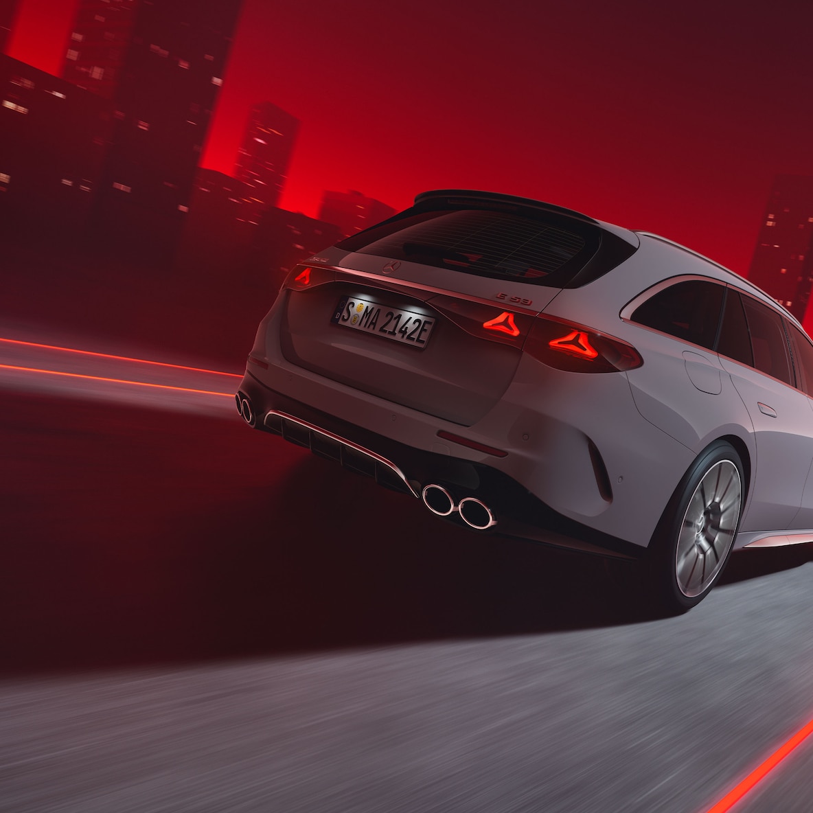 En kørende Mercedes-AMG E 53 HYBRID 4MATIC+ stationcar på en rød baggrund set bagfra.