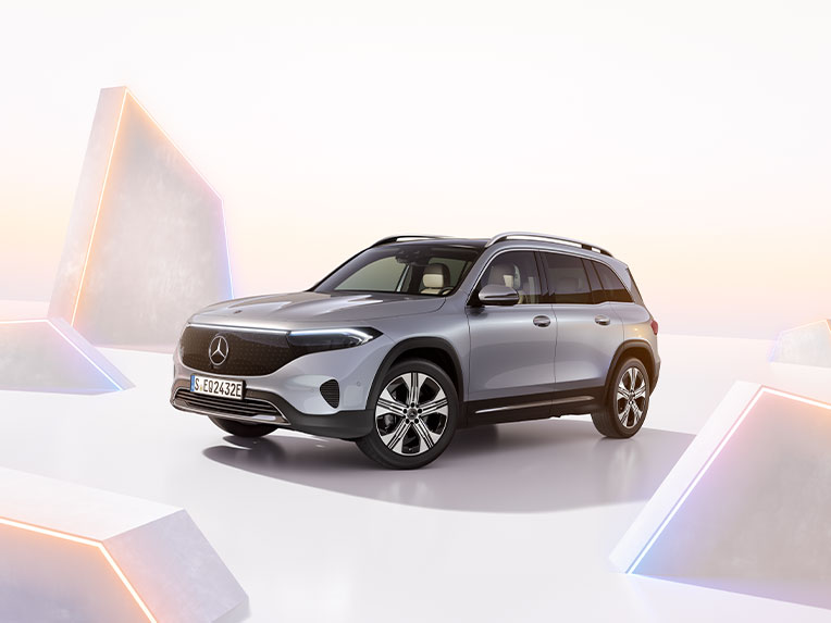EQB | Mercedes-Benz Mercedes-Benz EQB set skråt fra siden på en grafisk baggrund