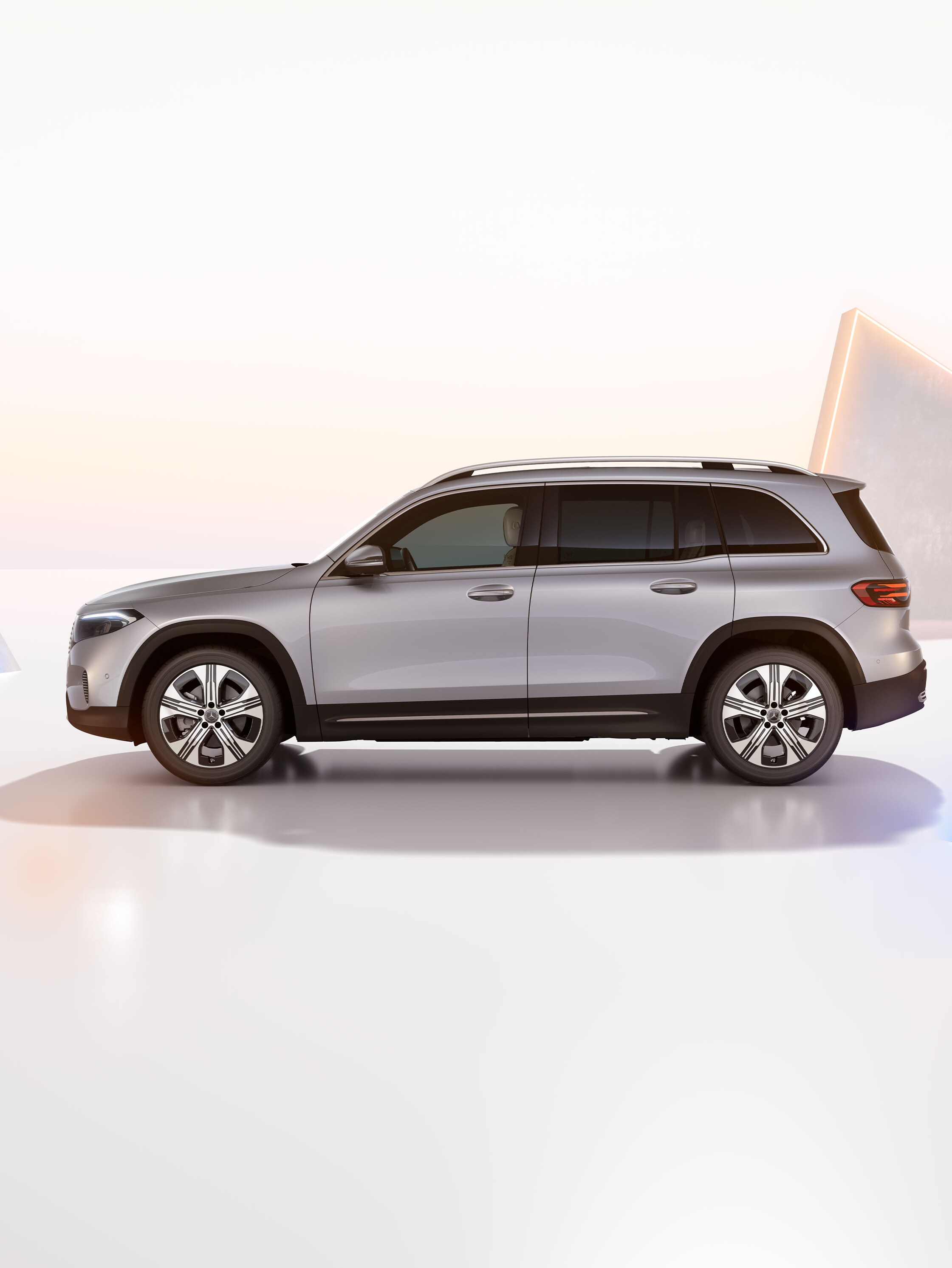 Lys grå Mercedes-Benz EQB set fra siden på kunstfærdig baggrund