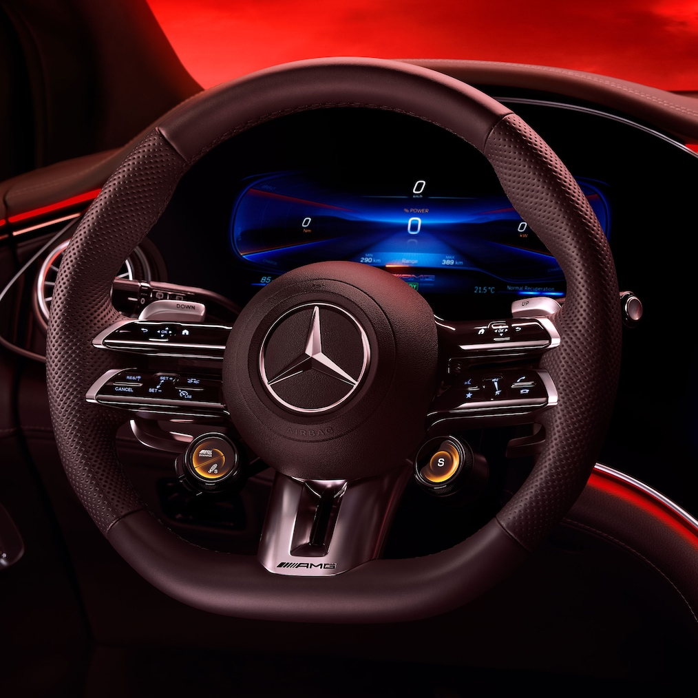 Billede af AMG Performance-rattet, set fra førersædet mod en rød baggrund.