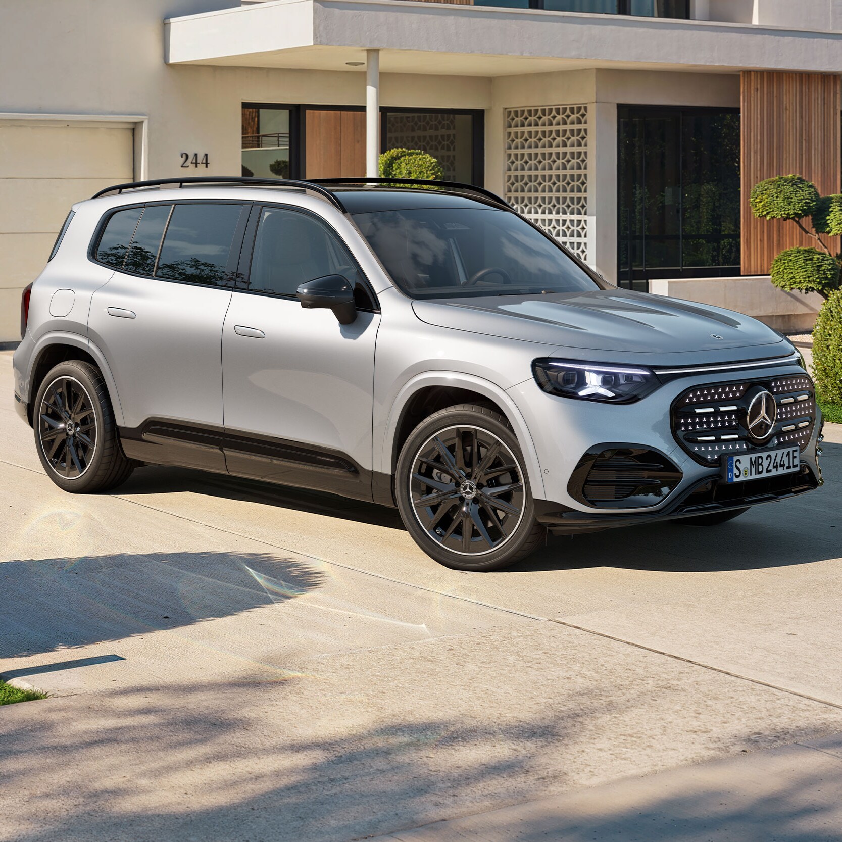 Den nye fuldelektriske GLB fra Mercedes-Benz foran hus med garage