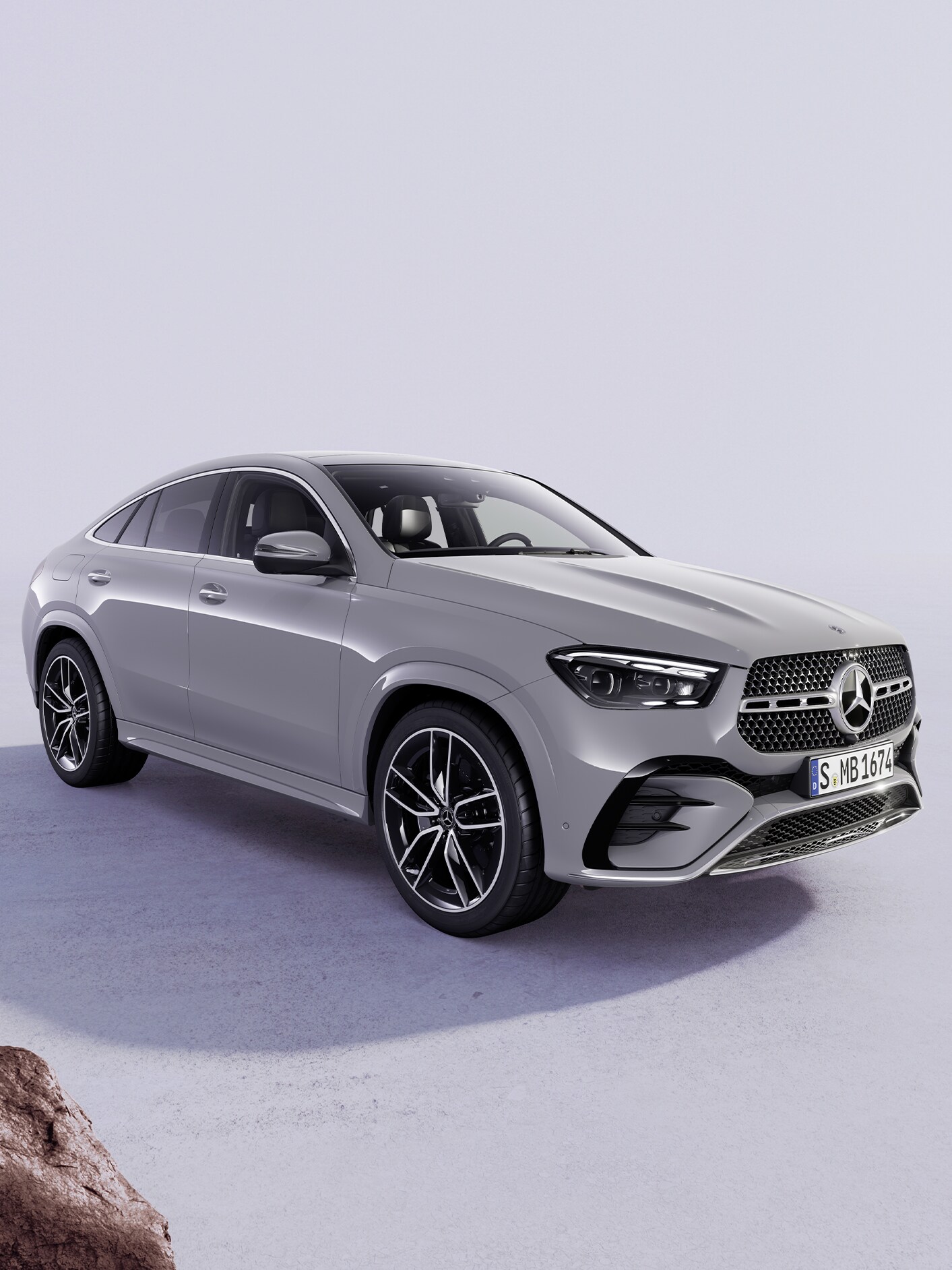 Grå Mercedes-Benz bil set skråt forfra på en minimalistisk baggrund