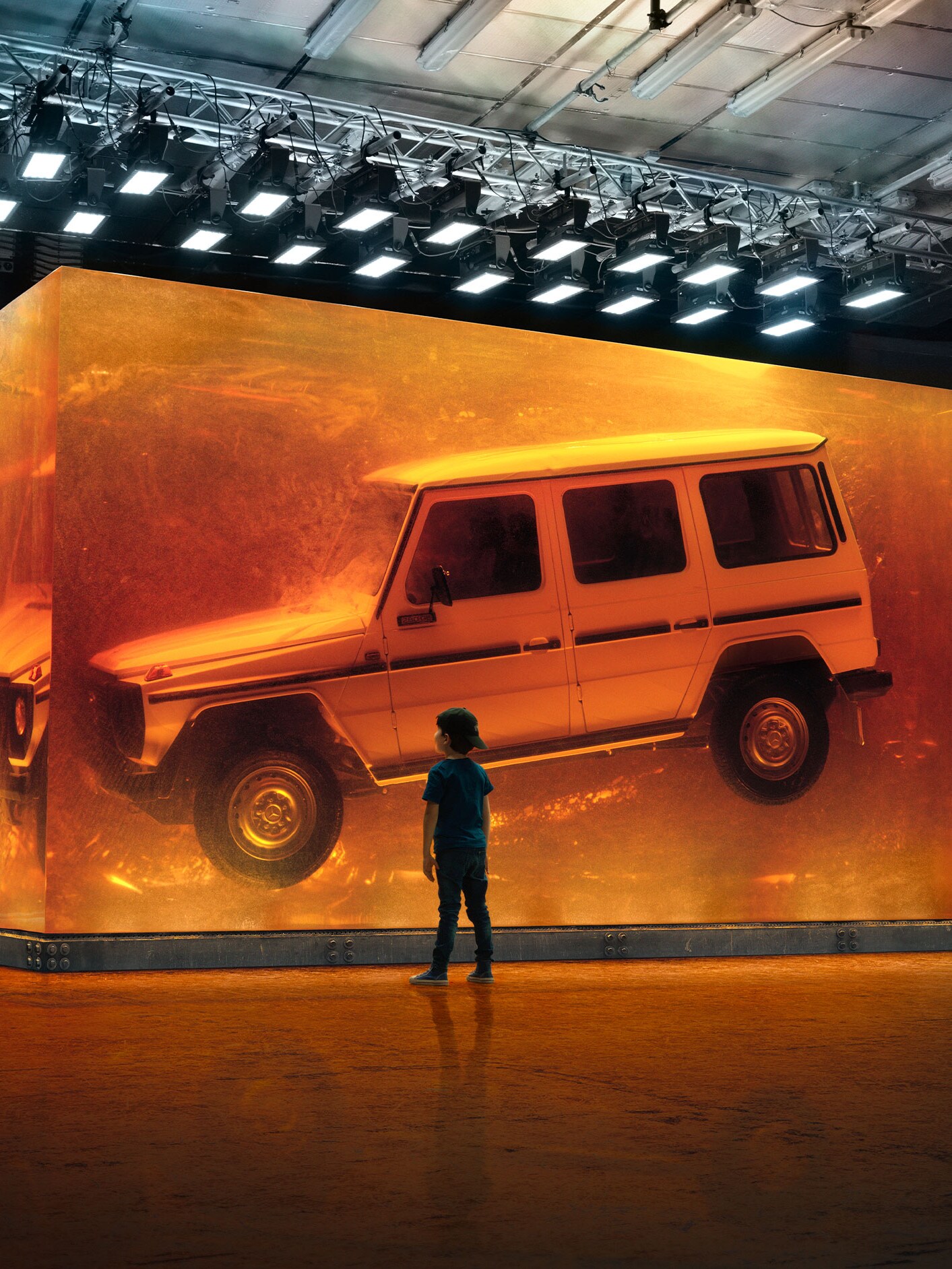 Dreng ser på svævende Mercedes-Benz G-Klasse udstillet i glas