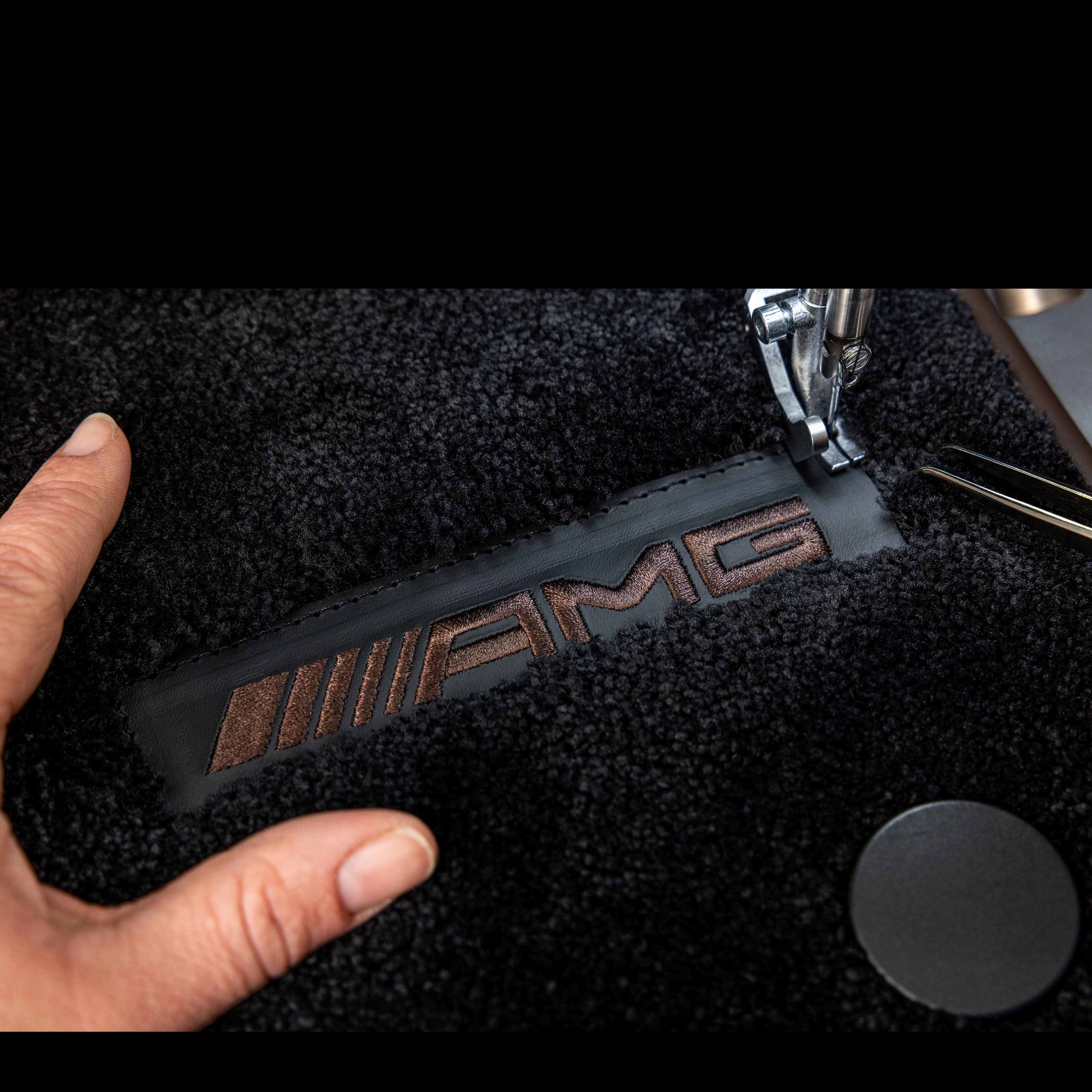 MANUFAKTUR | Mercedes-AMG MANUFAKTUR-påskrift på en mørk overflade i en Mercedes-AMG.