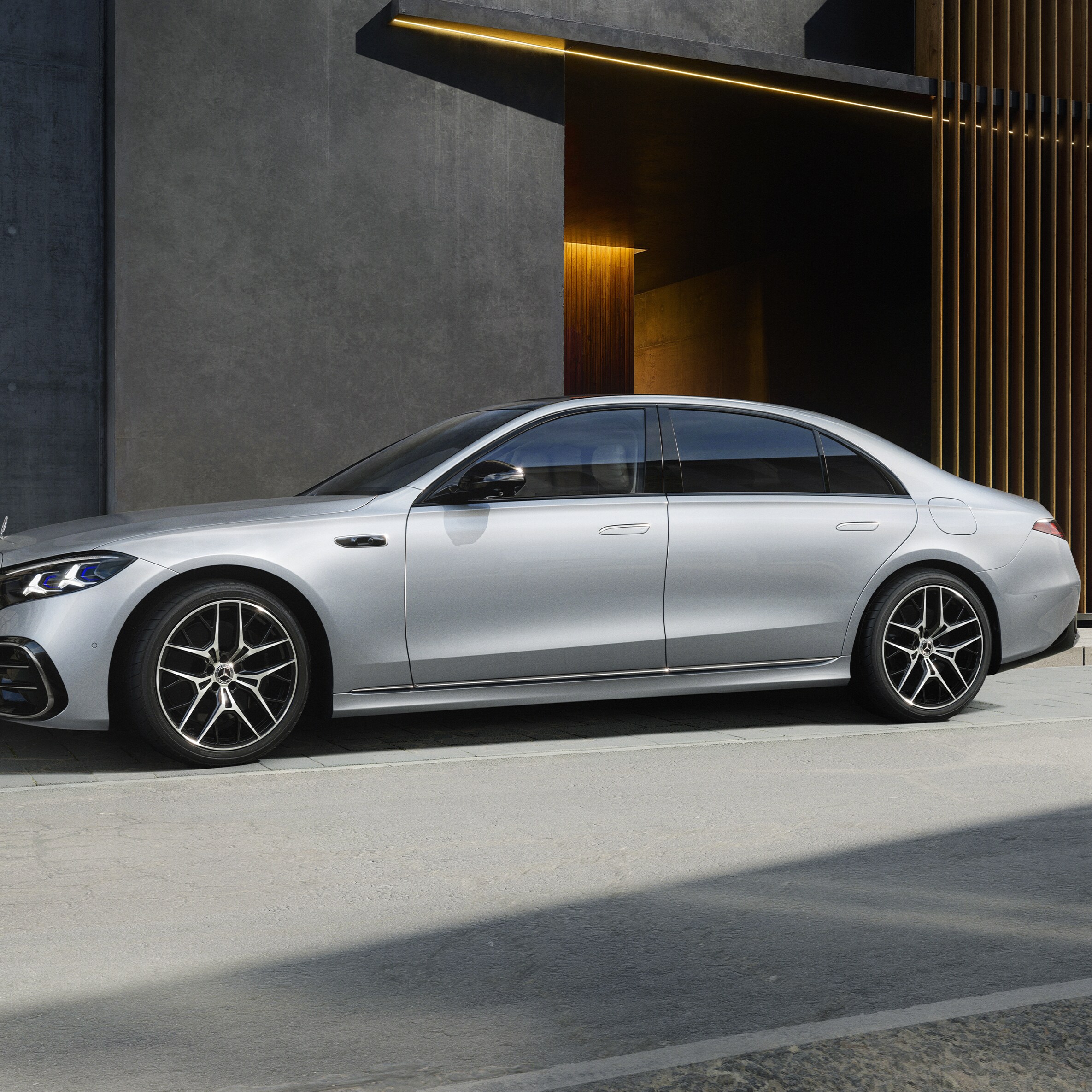 Sølvfarvet Mercedes-Benz S-Klasse Lang parkeret ved kantsten set fra siden