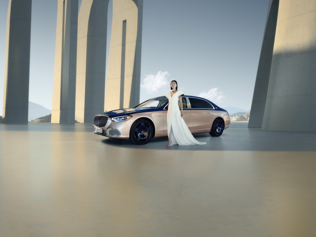 Kvinde i hvid kjole foran Mercedes-Maybach bil i tofarvet lakering