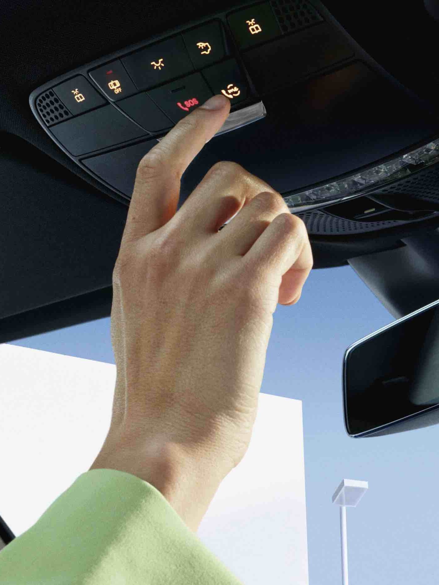 Person trykker på tasten i tagbetjeningsenheden i en Mercedes-Benz