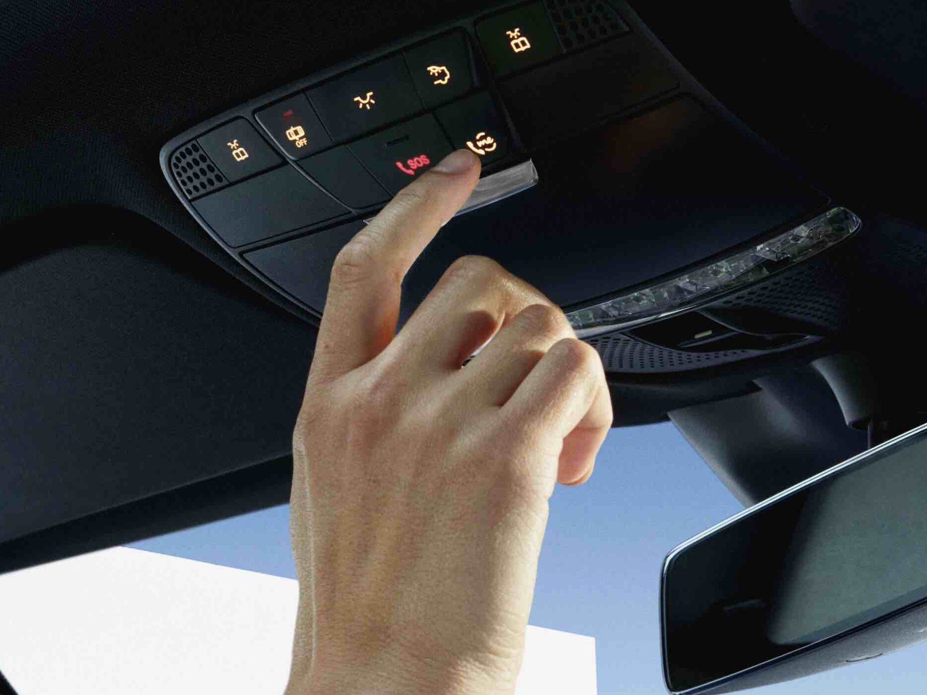 Person trykker på tasten i tagbetjeningsenheden i en Mercedes-Benz