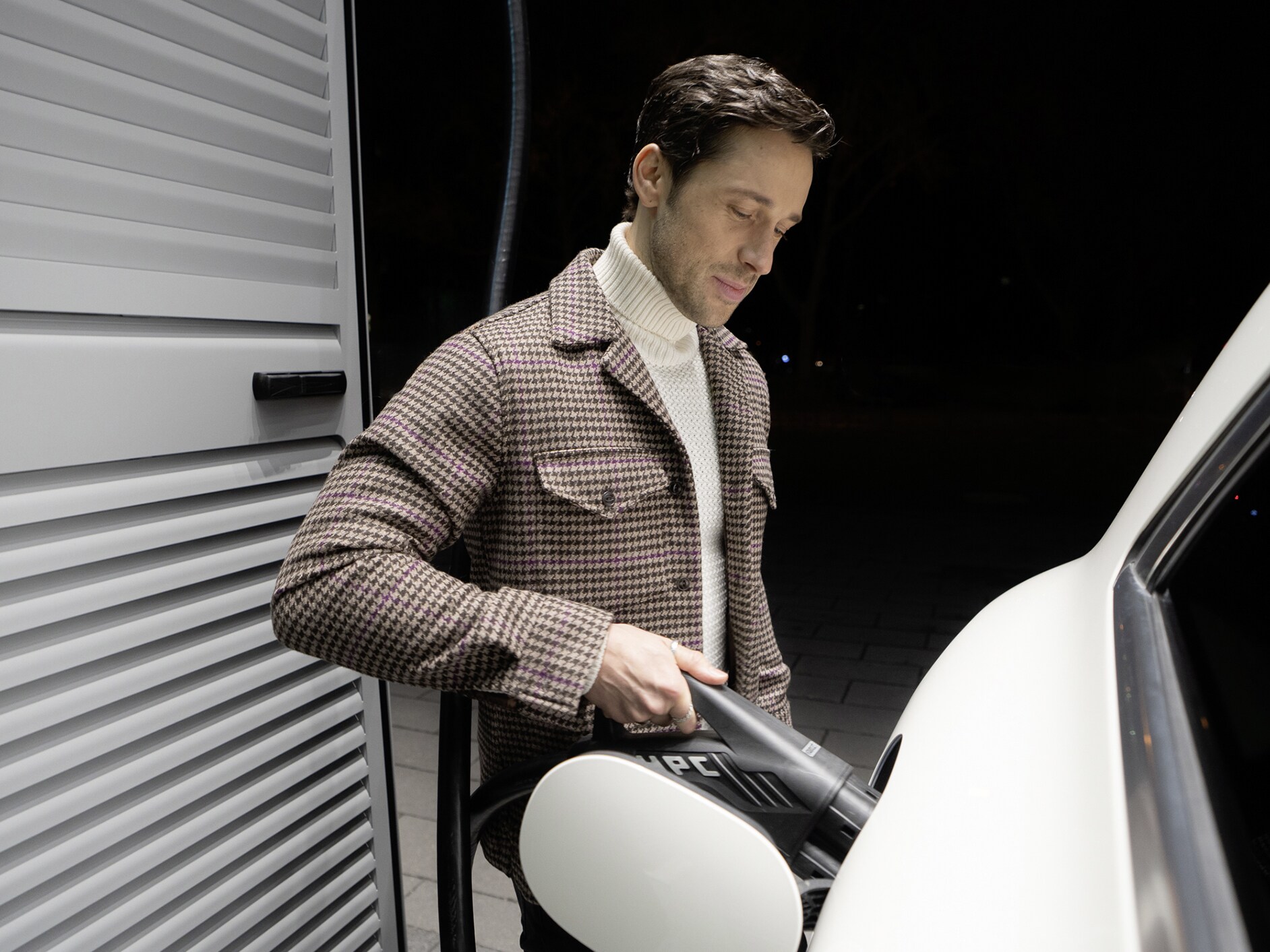 Mand oplader sin elektriske Mercedes-Benz bil ved en ladestander