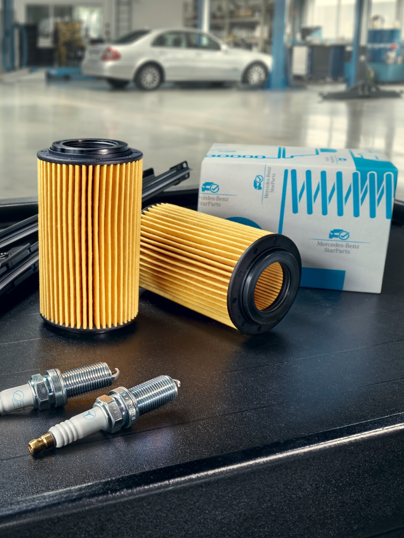 Forskellige Mercedes-Benz reservedele liggende på bord på værksted