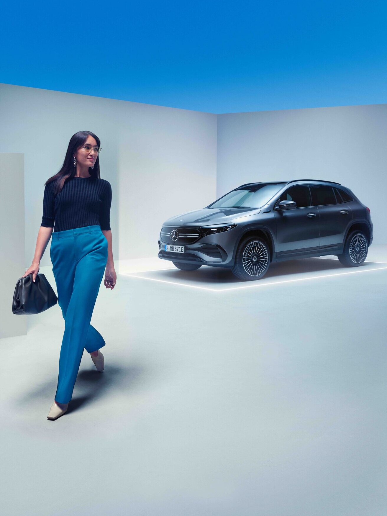 Kvinde med taske går væk fra sin parkerede Mercedes-Benz